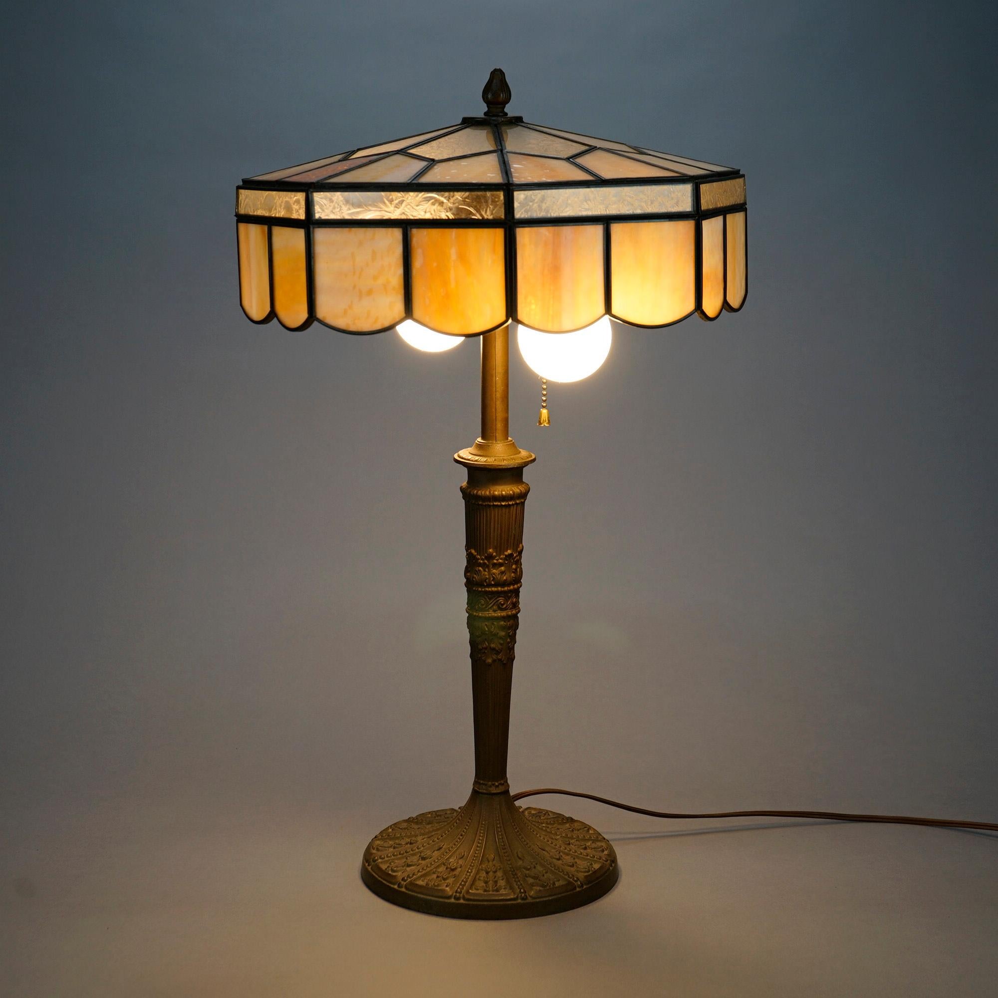 An antique Arts and Crafts table lamp in the manner of Bradley and Hubbard offers slag glass shade over double socket cast base, c1920

Measures- 22.5'' H x 12.75'' W x 12.75'' D.