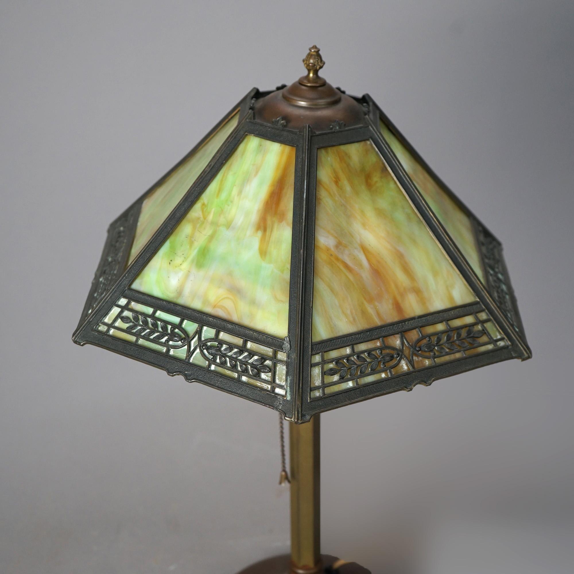 An antique Arts and Crafts Bradley & Hubbard table lamp offers shade with cast frame having pierced foliate band and housing slag glass panels over single cast base, c1920

Measures - 20.5