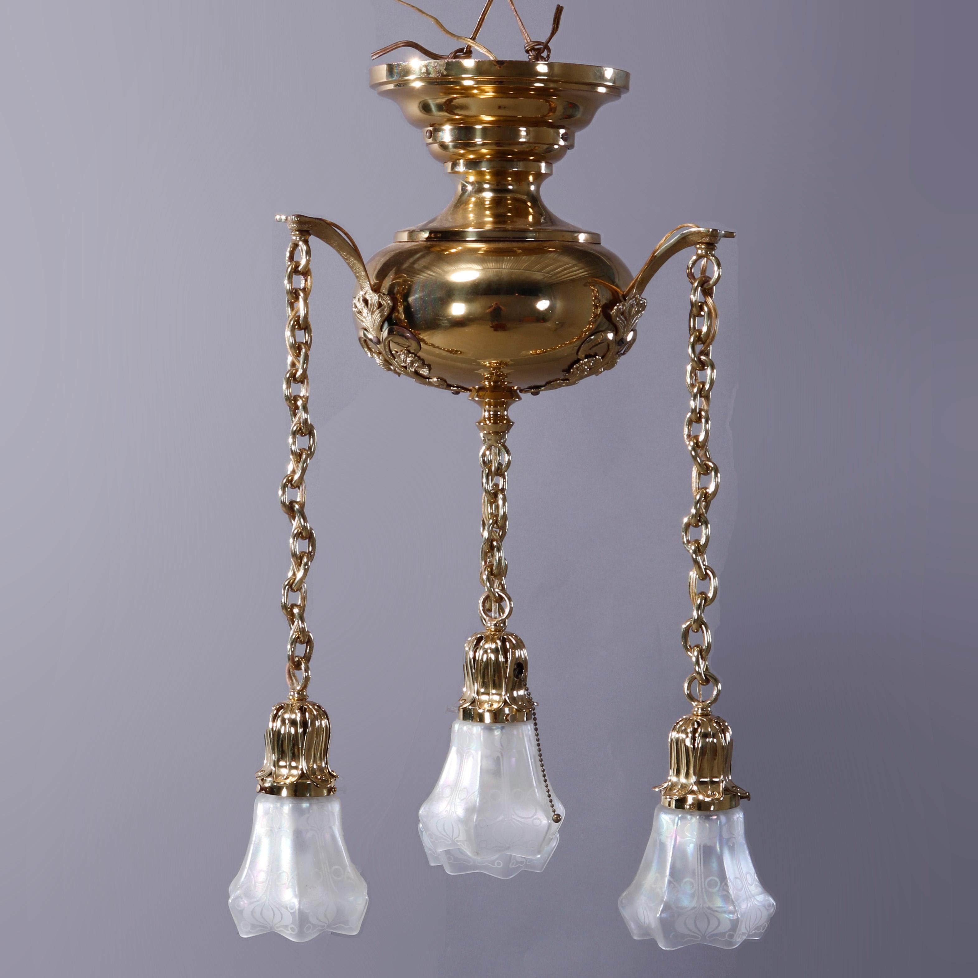 An antique Arts & Crafts ceiling mount hanging light fixture offers brass construction with central globe having scrolled foliate mounts and four drop lights terminating in tulip form glass shades, c1920

Measures - 30''H x 16''W x 16''D.
   