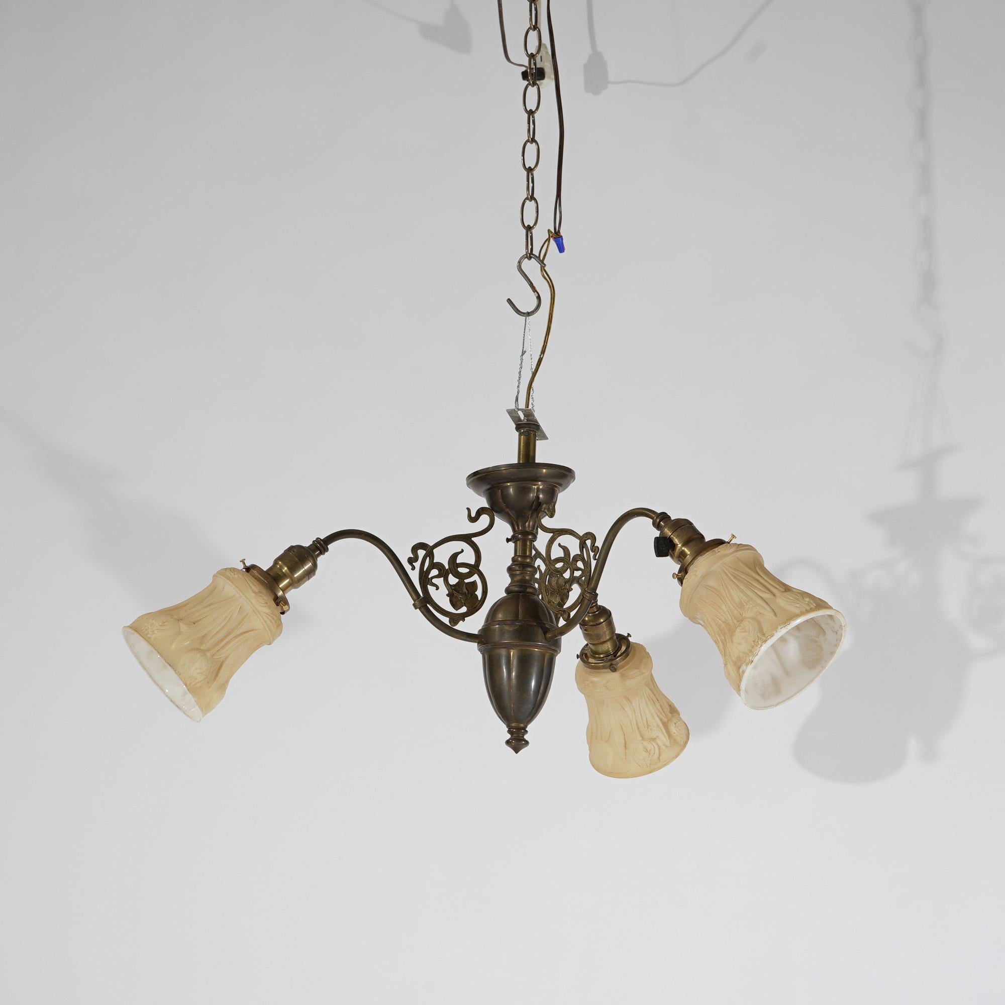 An antique Arts and Crafts chandelier offers brass frame with urn form font having three scroll form arms terminating in art glass shades, c1920

Measures - 20