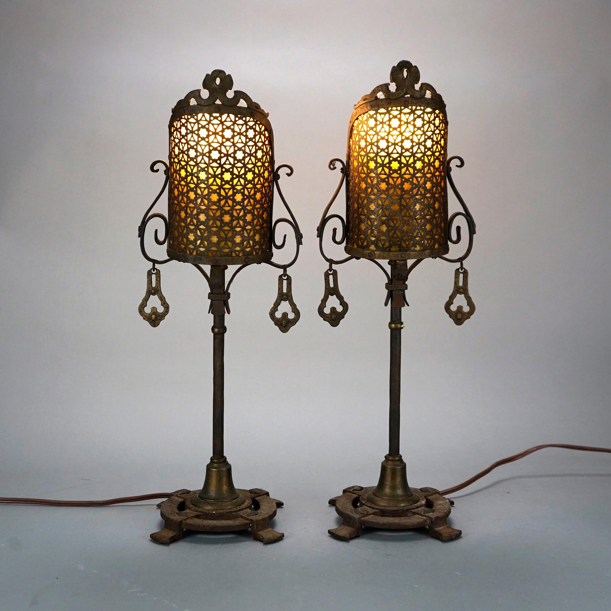 An antique Arts & Crafts pair of accent table lamps offer bronzed and reticulated screens having Moorish design over sing socket cast base with embossed tribal design and base having stylized paw feet, c1920.

Measures- 22.5''H x 7.5''W x