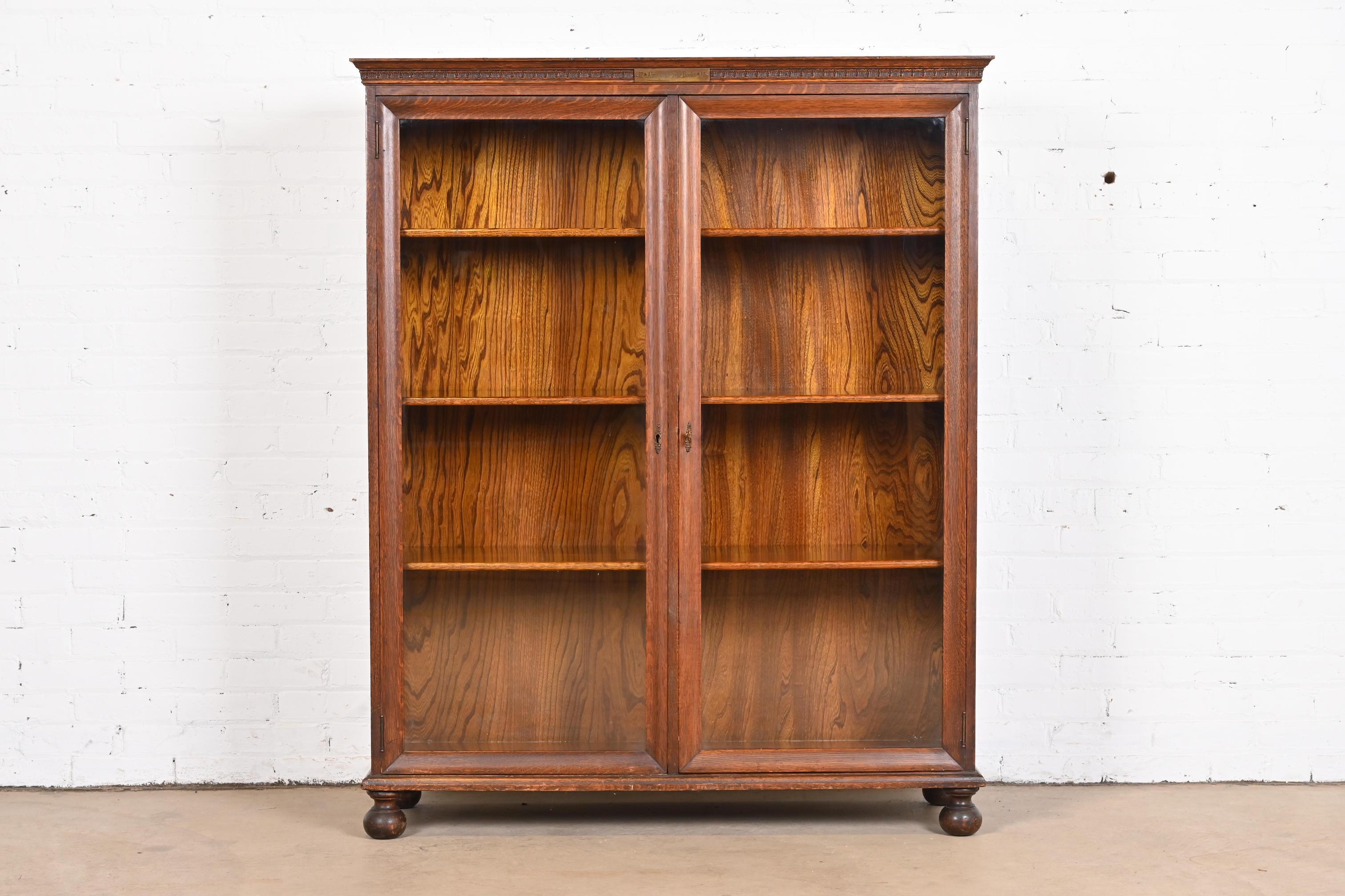 A beautiful antique Arts & Crafts or American Empire double bookcase cabinet

In the manner of Stickley Brothers

USA, circa 1900

Carved oak, with glass front doors and original brass hardware. Cabinet locks, and key is included.

Measures: