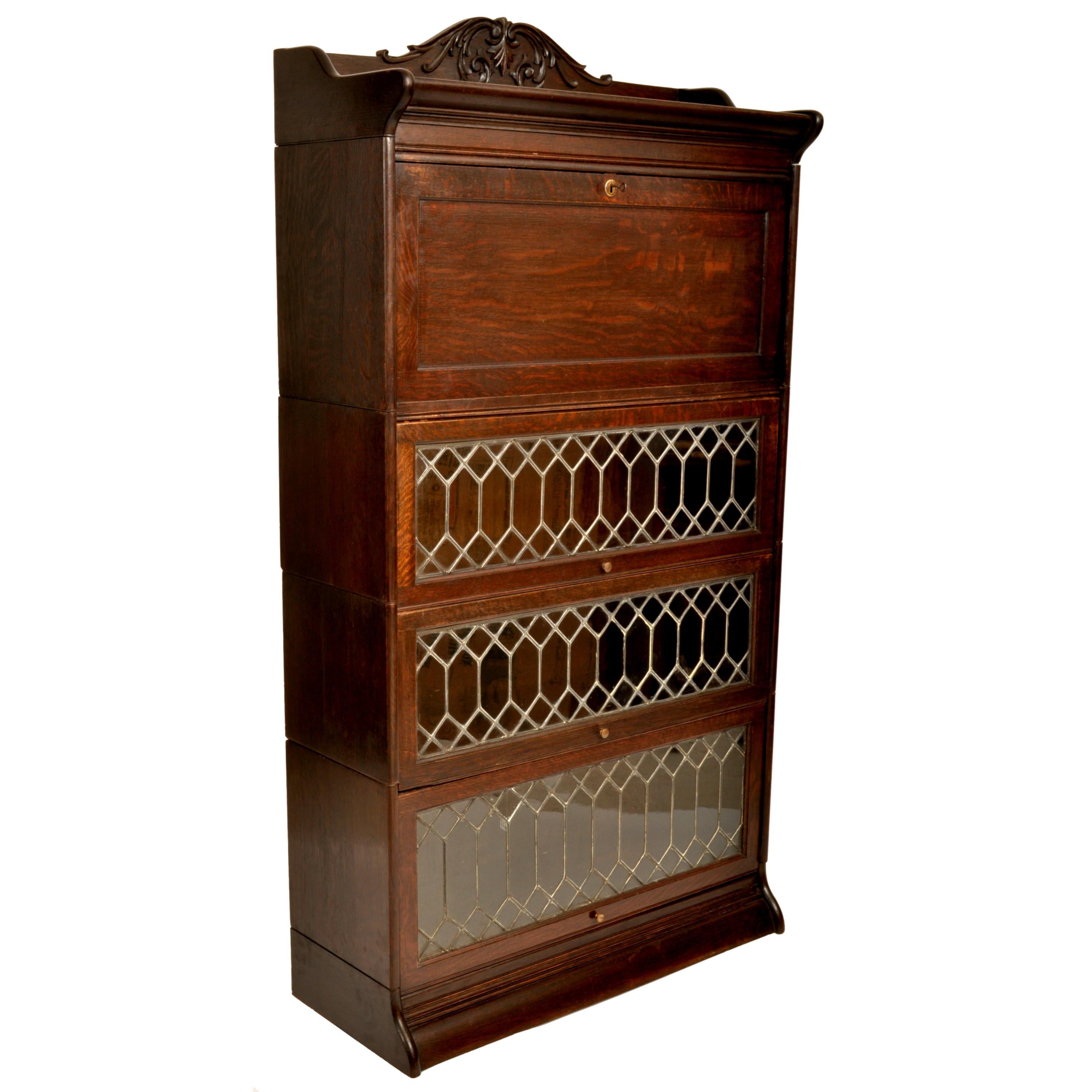 A good antique American Arts & Crafts oak lawyer's/barrister's bookcase/desk, circa 1900.
The six section bookcase having an ogee shaped top with a carved crest, below is a locking fall front desk with the original key and a fitted interior