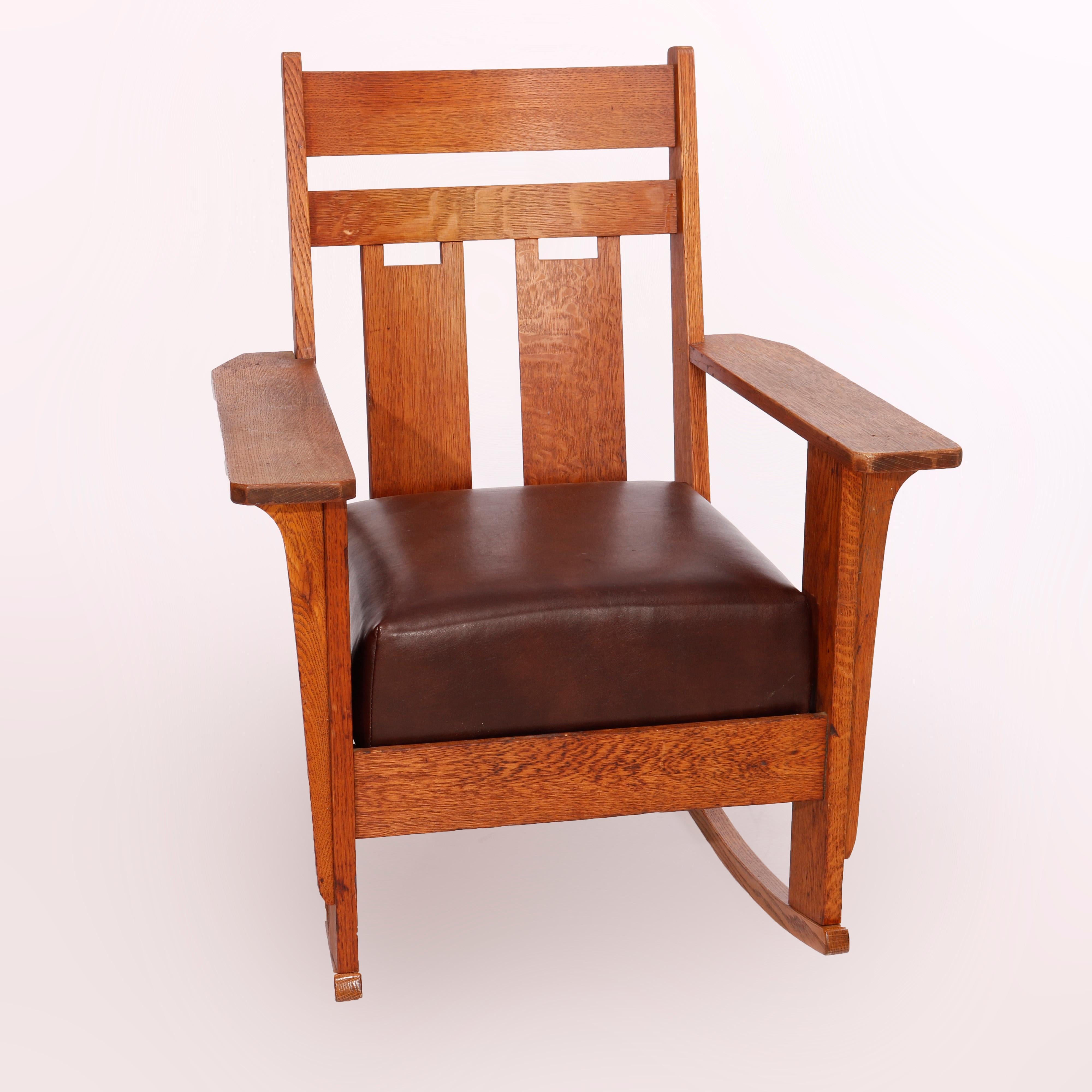 An antique Arts and Crafts rocker by Charles Stickley offers oak construction with slat back and cushioned seat, unmarked, c1910

Measures - 35.5'' H x 29'' W x 29.5'' D; 17'' seat height.