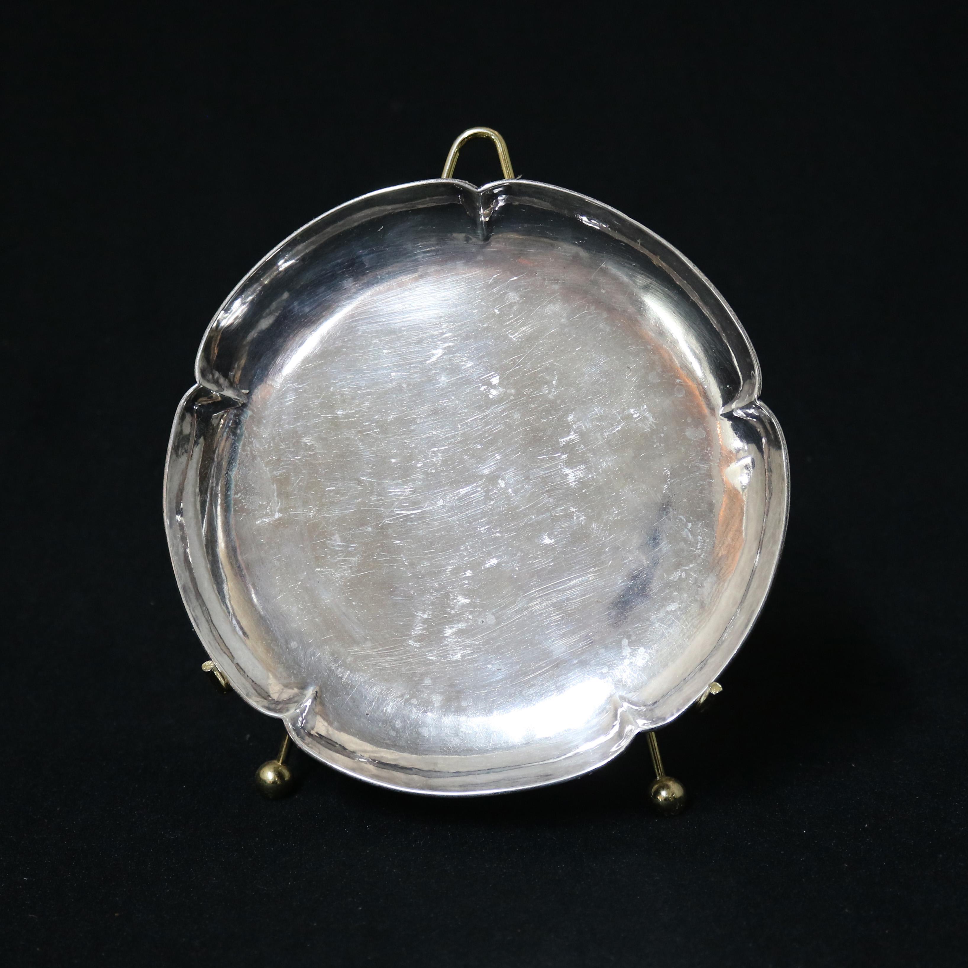 An antique Arts and Crafts tray by Chicago offers hand wrought sterling silver construction with stylized crimped circular edge, maker stamp en verso as photographed, 5.64 toz, c1915

Measures - .5''height x 7.5''wide x 7.5''diameter.