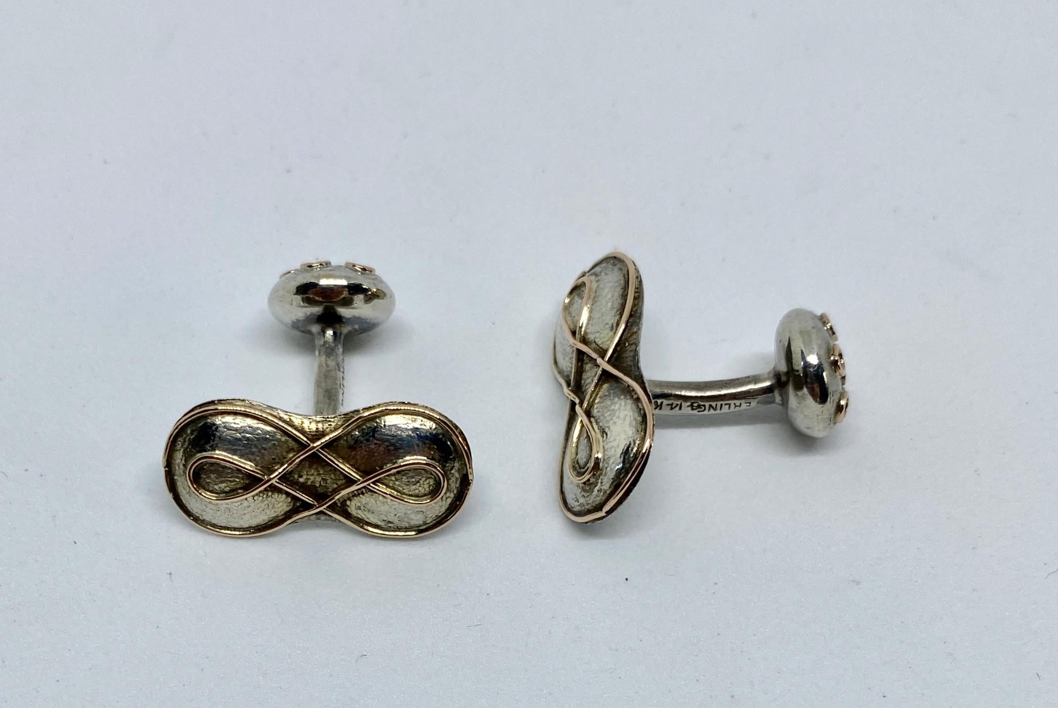 An extraordinary pair of handmade cufflinks in hammered sterling silver with 14K yellow gold from the Arts & Crafts era.

Made by George W. Shiebler of New York (active from 1876 to 1910), these cufflinks feature figure-8 fronts measuring 22.6 by