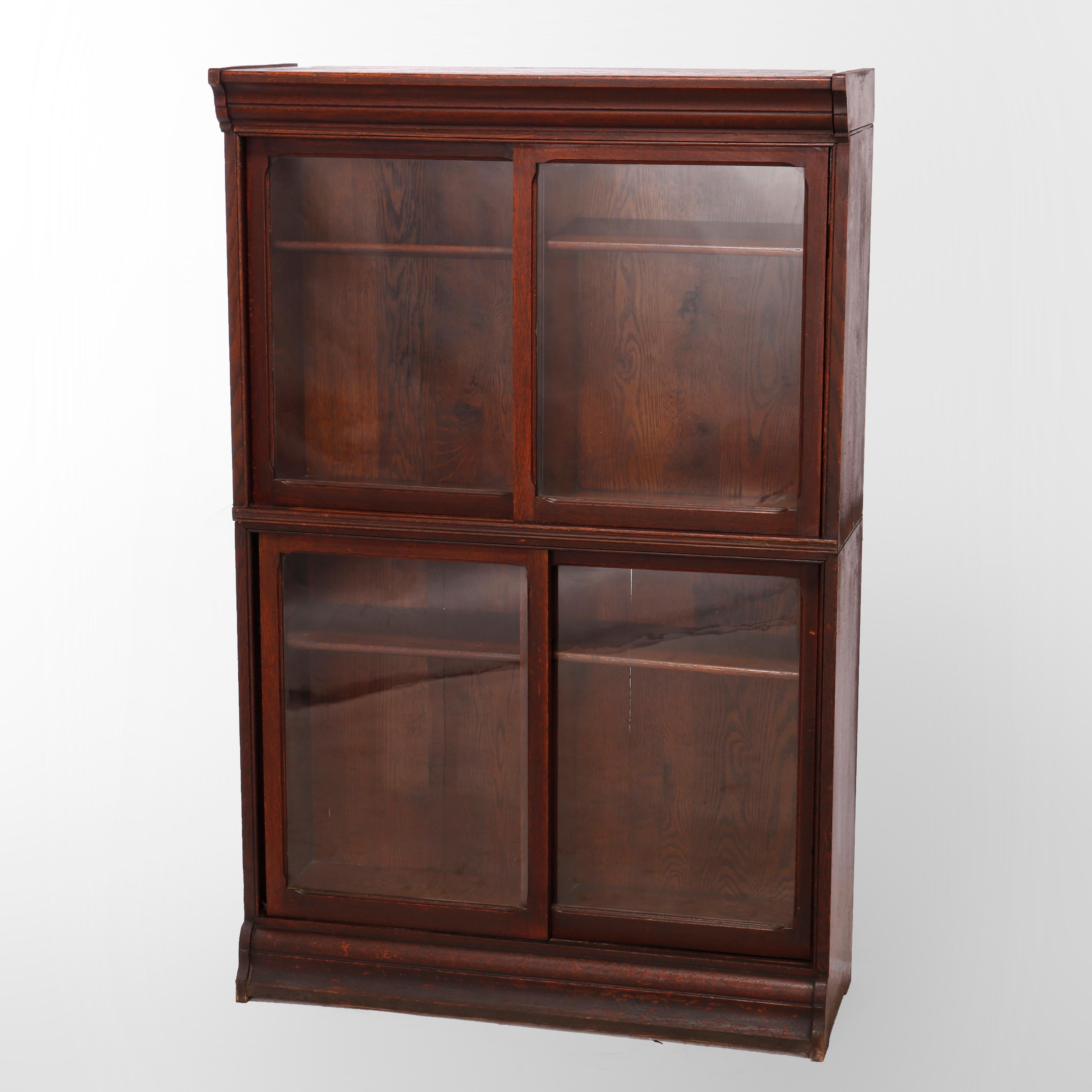 An antique Arts and Crafts bookcase by Danner offers quarter sawn oak construction with two stacks, each having sliding glass doors opening to adjustable shelf interiors, raised on ogee base, c1910


Measures - 57.75''H x 37.25''W x 13.5''D overall;
