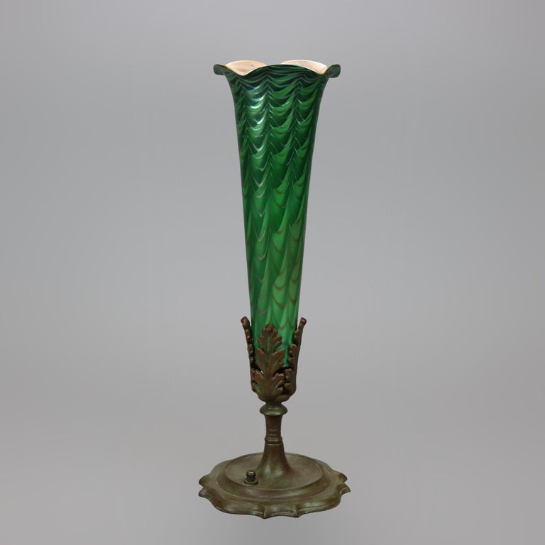 An Arts and Crafts table lamp by Durand offers flower form with flared art glass shade having green over marigold with ruffled rim, accommodates a 15w tube bulb, unsigned, c1930

Measures- 15.25''h x 5.25''w x 5.25''d.
 
Catalogue Note: Ask about
