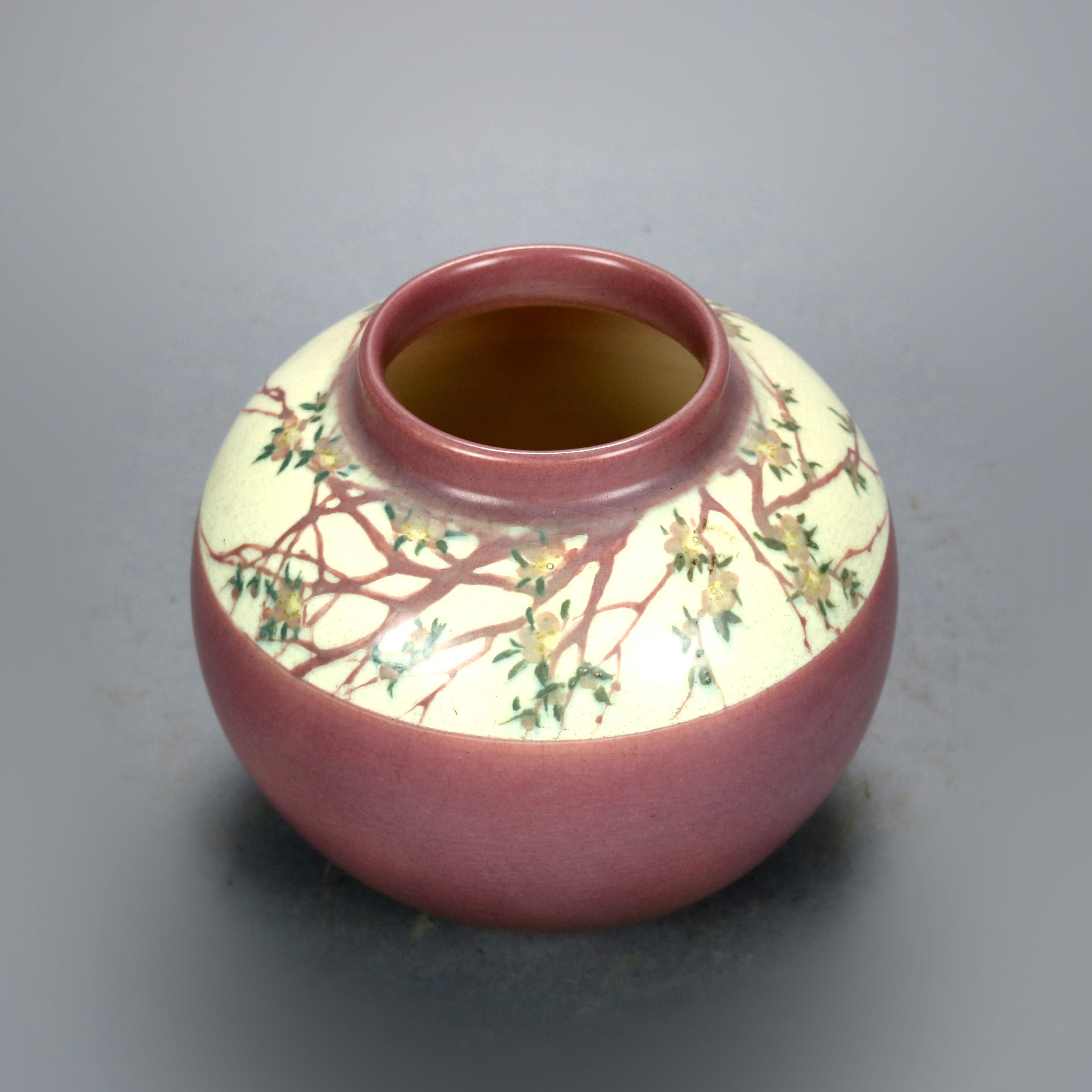 An antique Rookwood art pottery vase by E.T. Hurley offers chunk form with vellum glaze with a hand painted floral band, possibly cherry blossoms, signed on base as photographed, 1915.

Measures: 7
