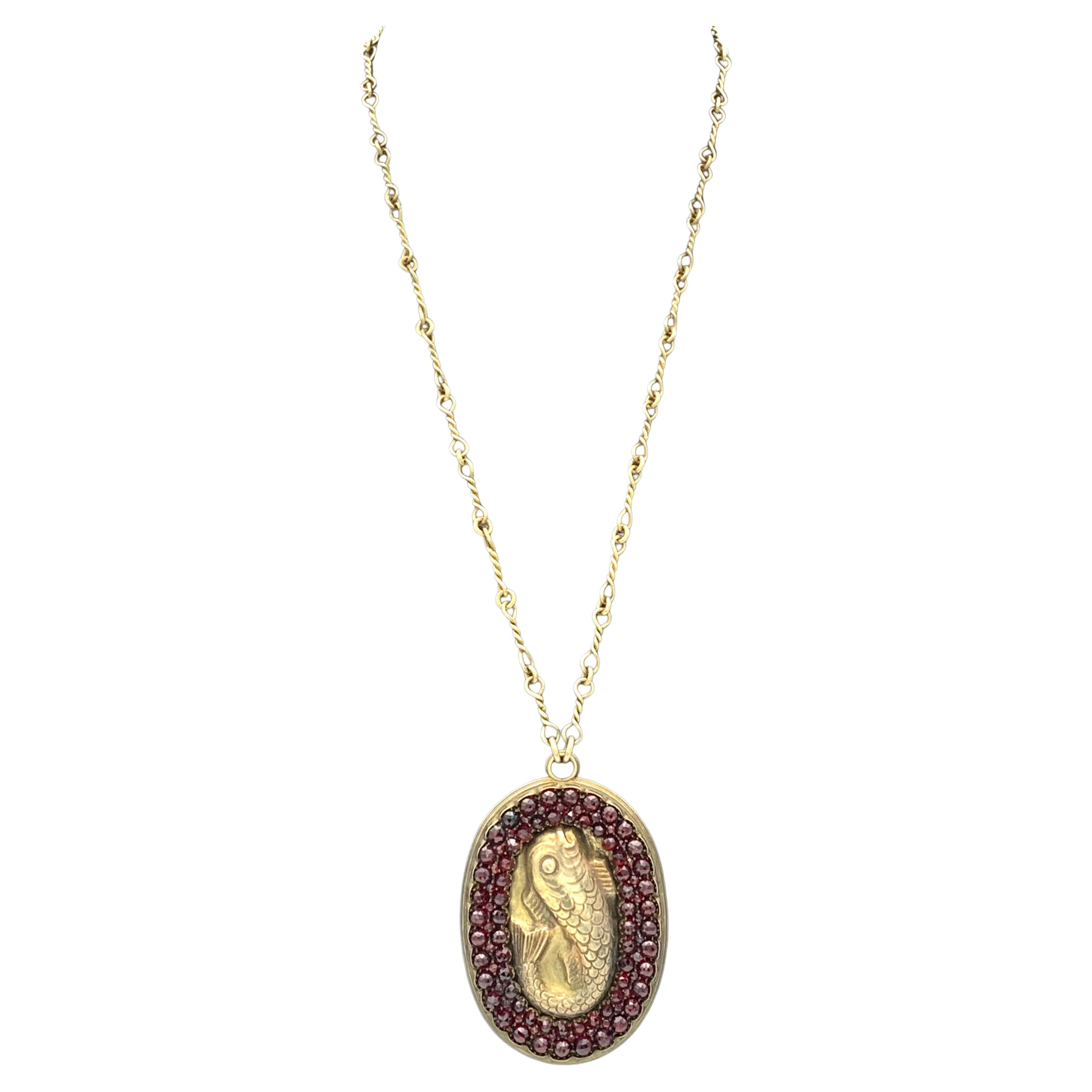 The pendant is set with three rows of graduated facetted garnets in various sizes. within anondulated frame. 
The length of the handmade  chain without the pendant meassures 26 cm, the pendant 7.1 cm. 
The pendant comes in its original unpolished