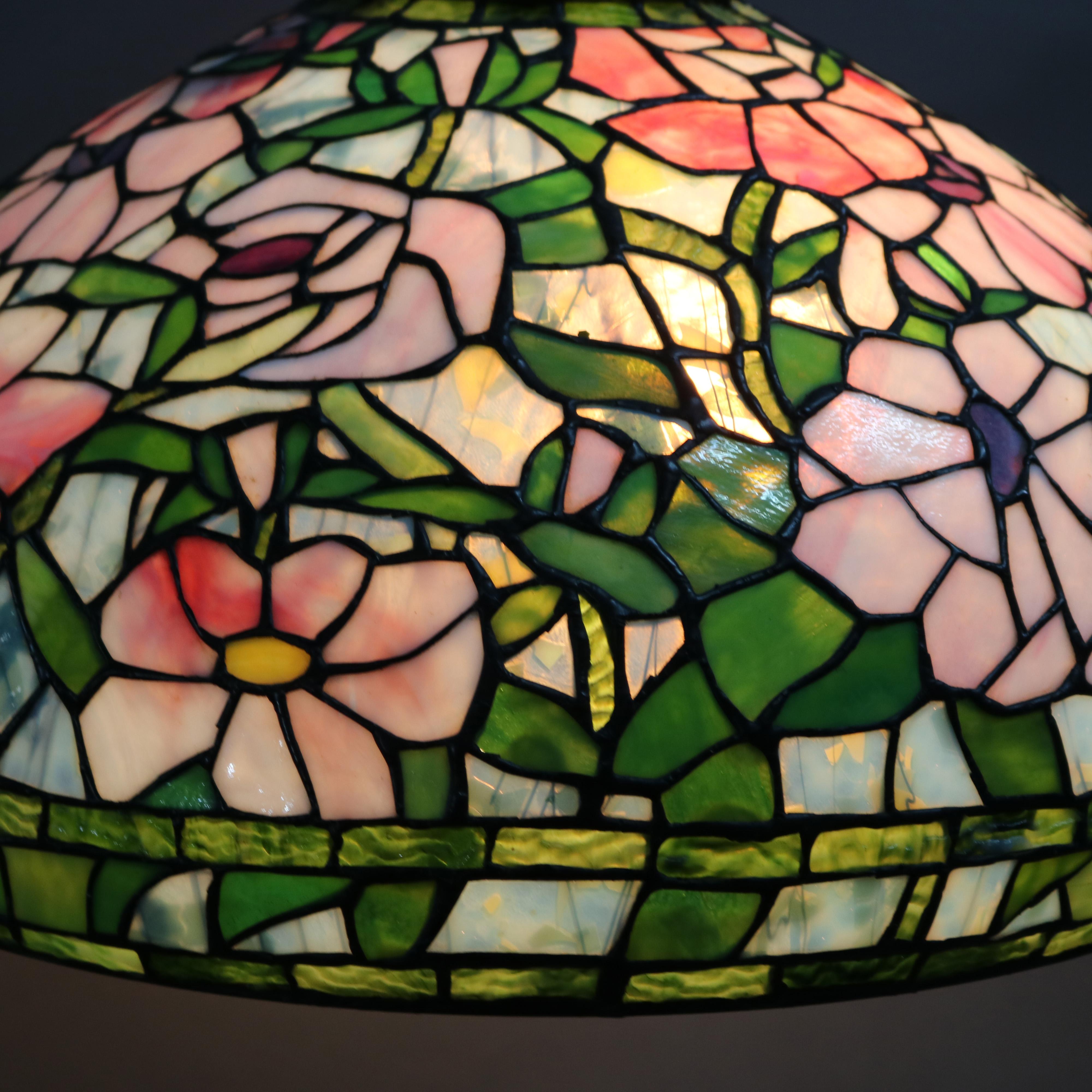 An antique Arts & Crafts hanging chandelier offers mosaic leaded slag glass dome with allover floral design over triple socket fixture, 20th century.

Measures: 37