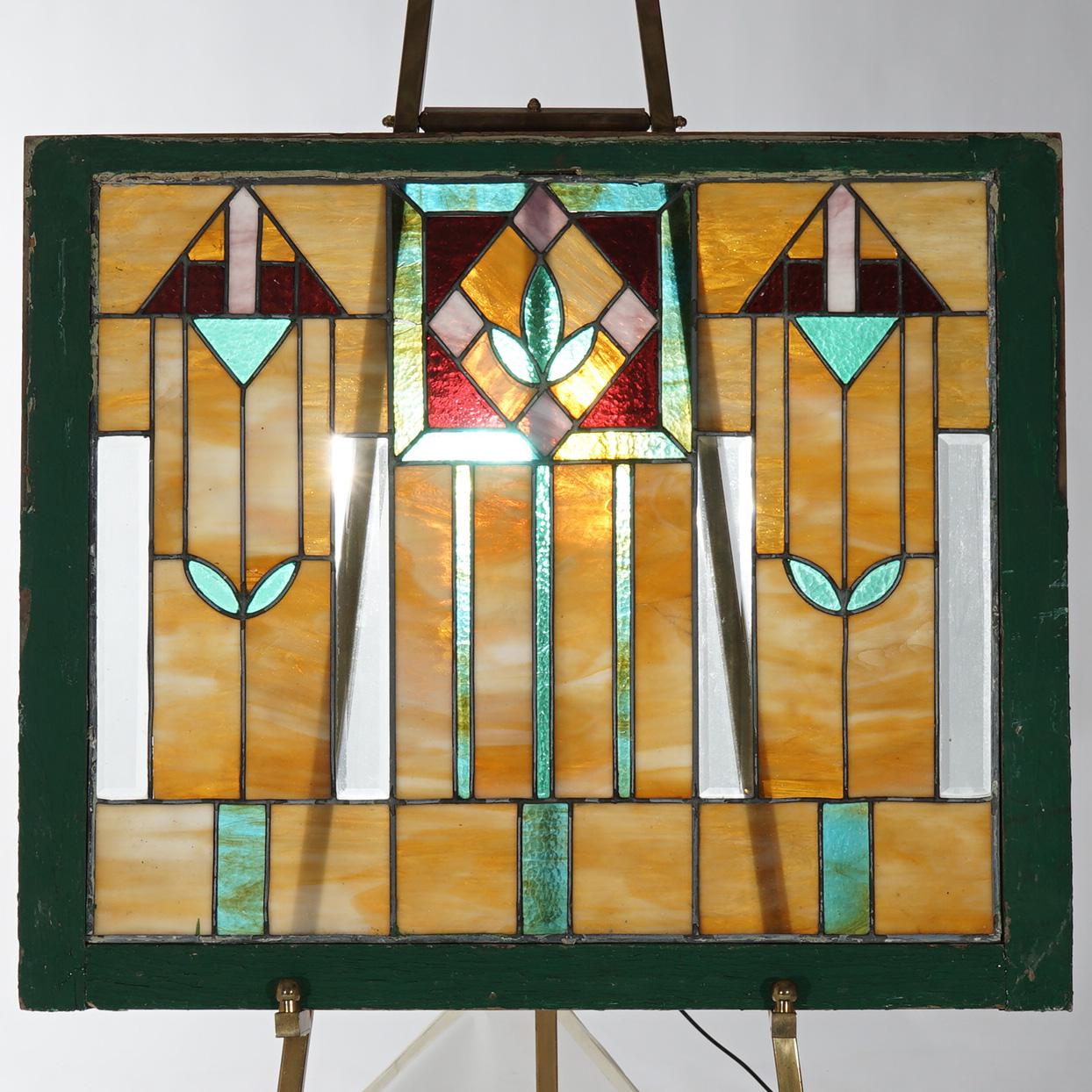 An antique Arts and Crafts window in the manner of Frank Lloyd Wright Prairie School offers leaded stained and slag glass with stylized floral design, seated in wood sash, c1910

Measures - 26.25