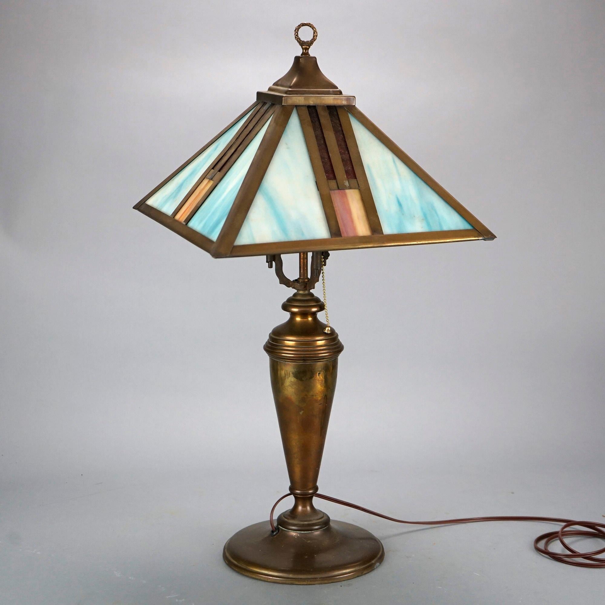 An antique Arts and Crafts table lamp in the matter of Frank Lloyd Wright offers paneled shade in geometric form housing slag glass panels over single socket cast base, c1920

Measures- 25.5''H x 13''W x 13''D.

Catalogue Note: Ask about DISCOUNTED