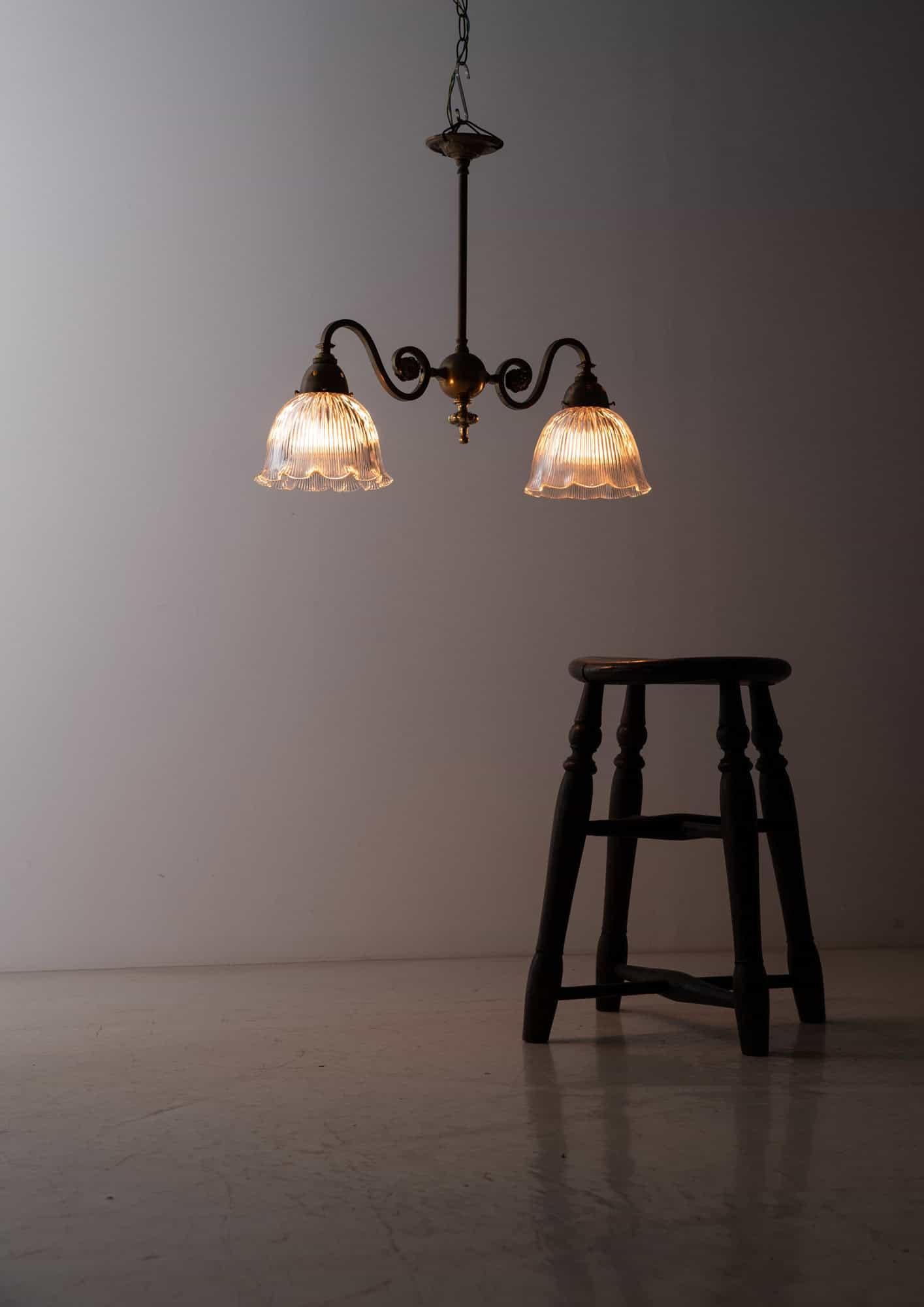 

An elegantly formed brass electrolier with opaline glass shades. c.1930

Made by GEC, beautifully designed brass two-branch electrolier with matched pair of Holophane glass shades. 

Fixes directly to ceiling and rewired to connect to mains.
