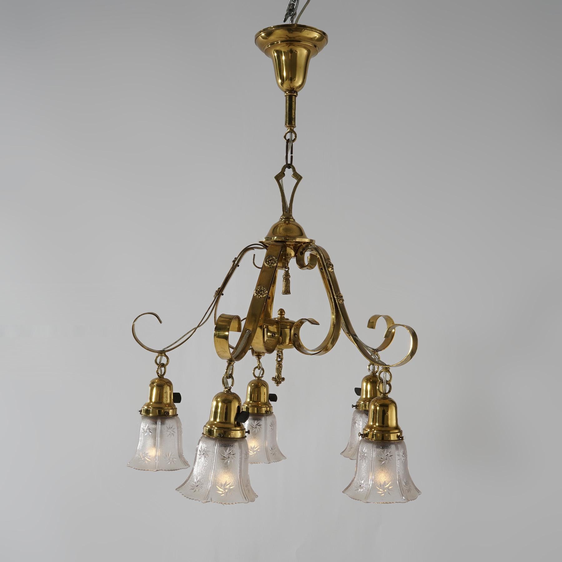 An antique Arts & Crafts chandelier offers gilt metal and brass frame with five scroll form arms terminating in embossed glass shades, circa 1920
Measures - 31