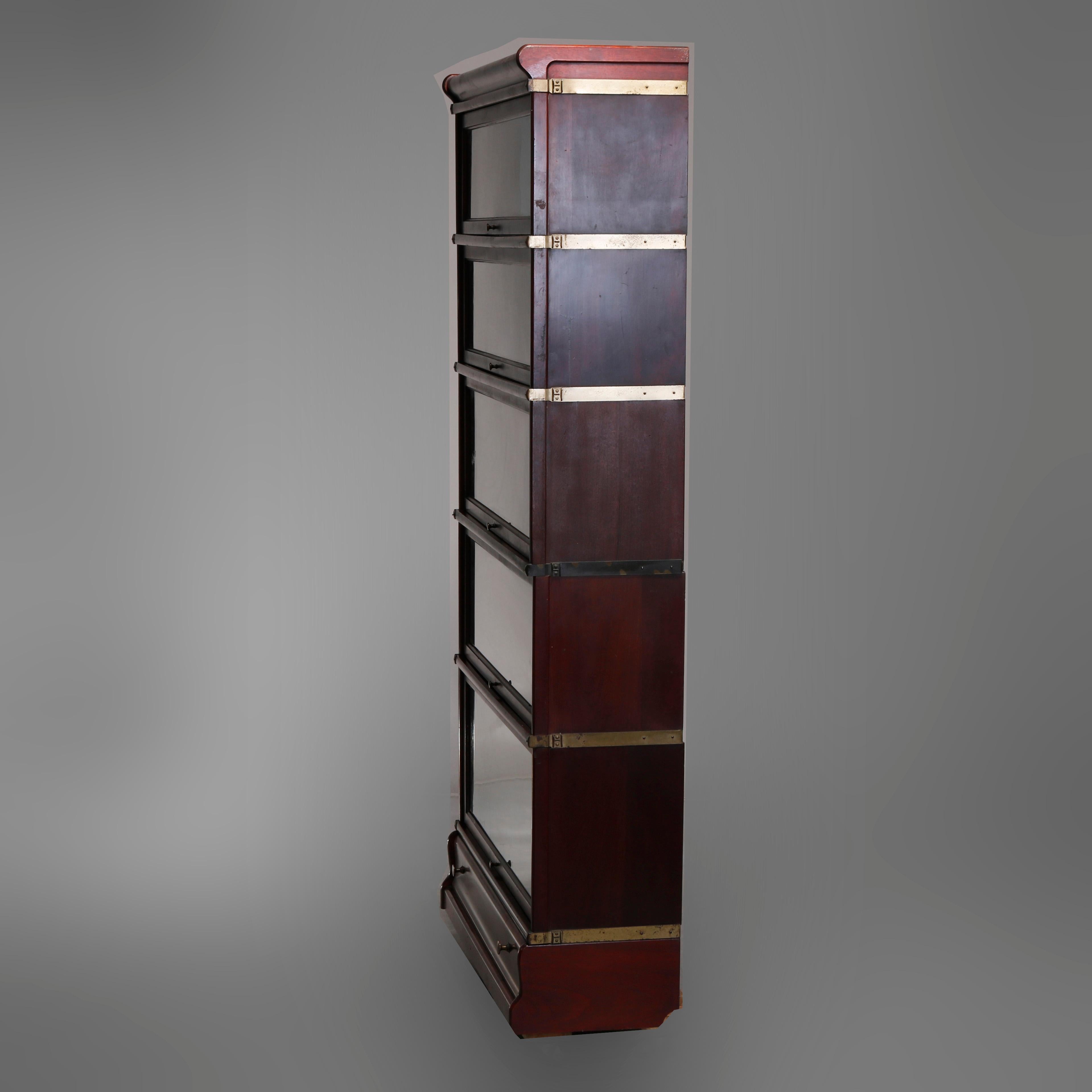 An antique Arts & Crafts Mission Barrister stacking bookcase by Globe Wernicke offers mahogany construction with five sections having pull-out glass doors and lower drawer, original labels as photographed, circa 1910

Measures: 69.75