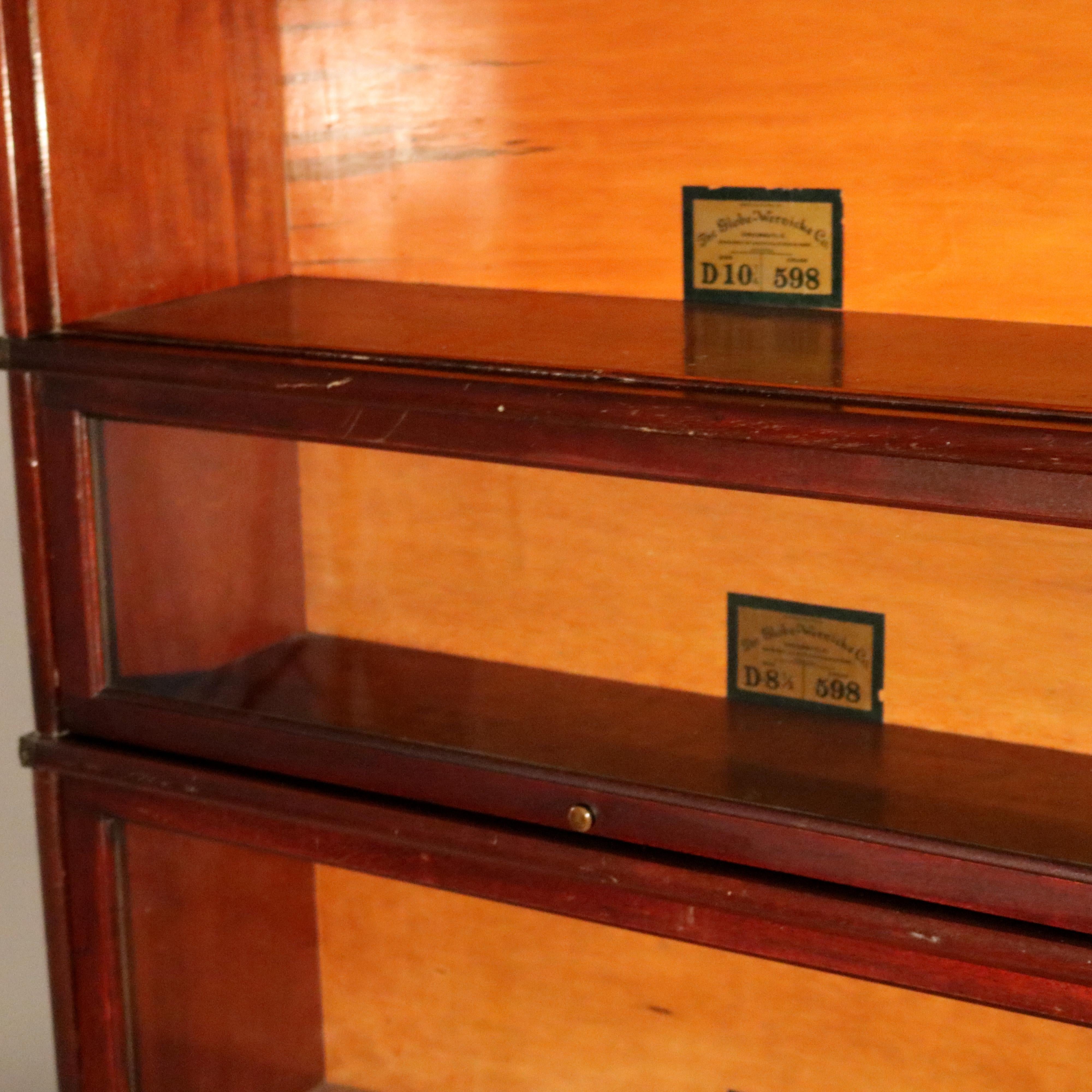 An antique Arts & Crafts barrister bookcase by Globe Wernicke offers mahogany construction with four stacks, each having slide out glass doors over lower ogee form base with long drawer, maker label as photographed, c1910.

Measures: 57.5