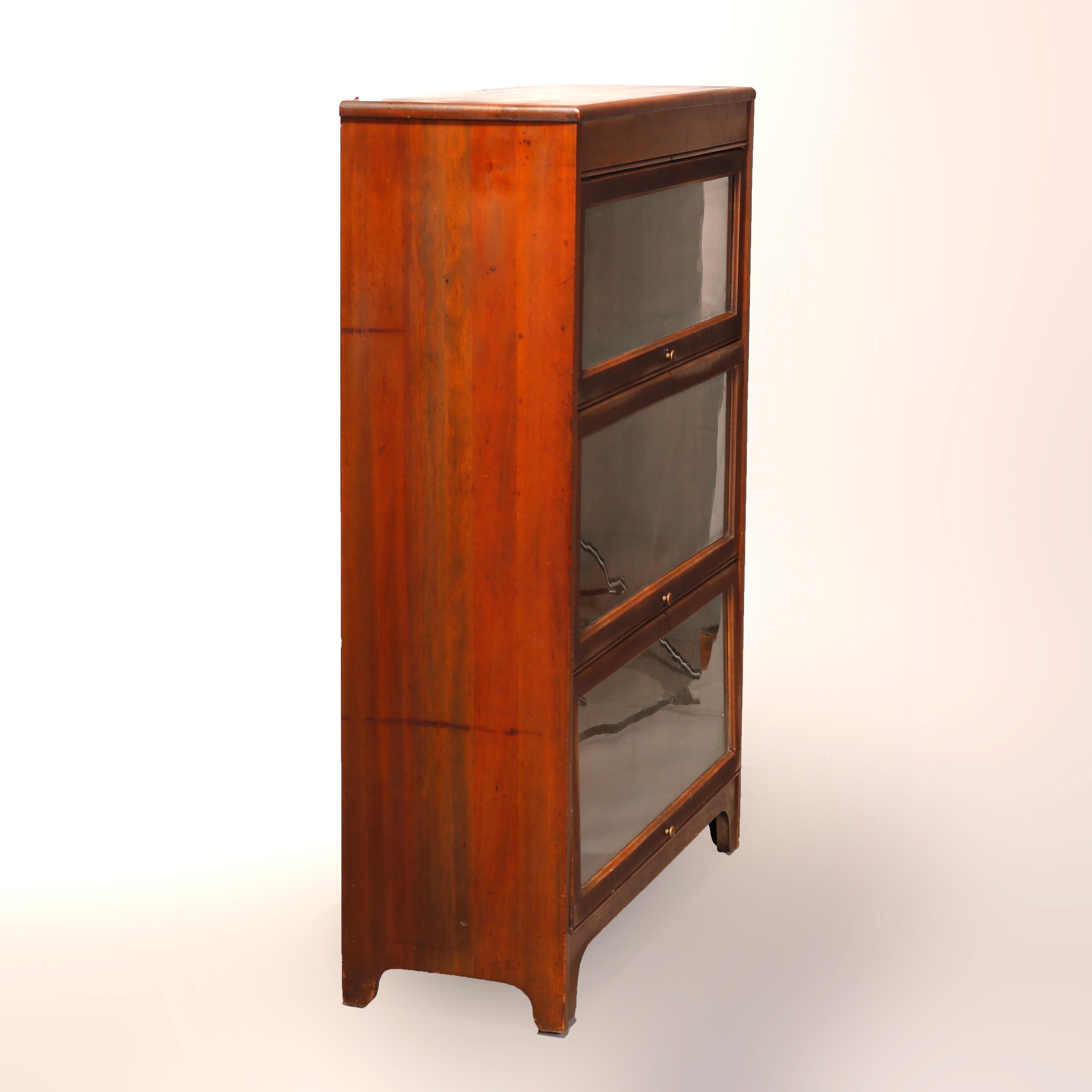An antique Arts & Crafts Barrister bookcase in the manner of Globe Wernicke offers mahogany with three stacks with pull out glass doors, raised on straight legs, circa 1910

Measures: 46.5