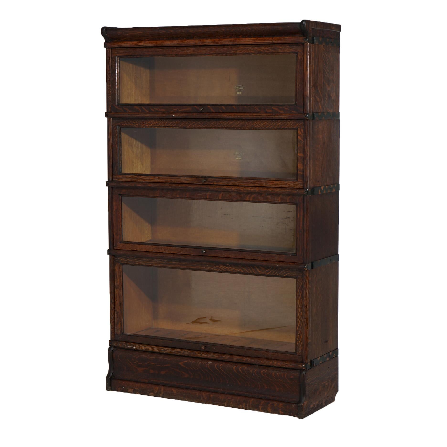 An antique Arts and Crafts barrister bookcase by Globe Wernicke offers quarter sawn oak construction with four stacks, each having pullout glass doors, and raised on and ogee base, c1910

Measures - 56.25