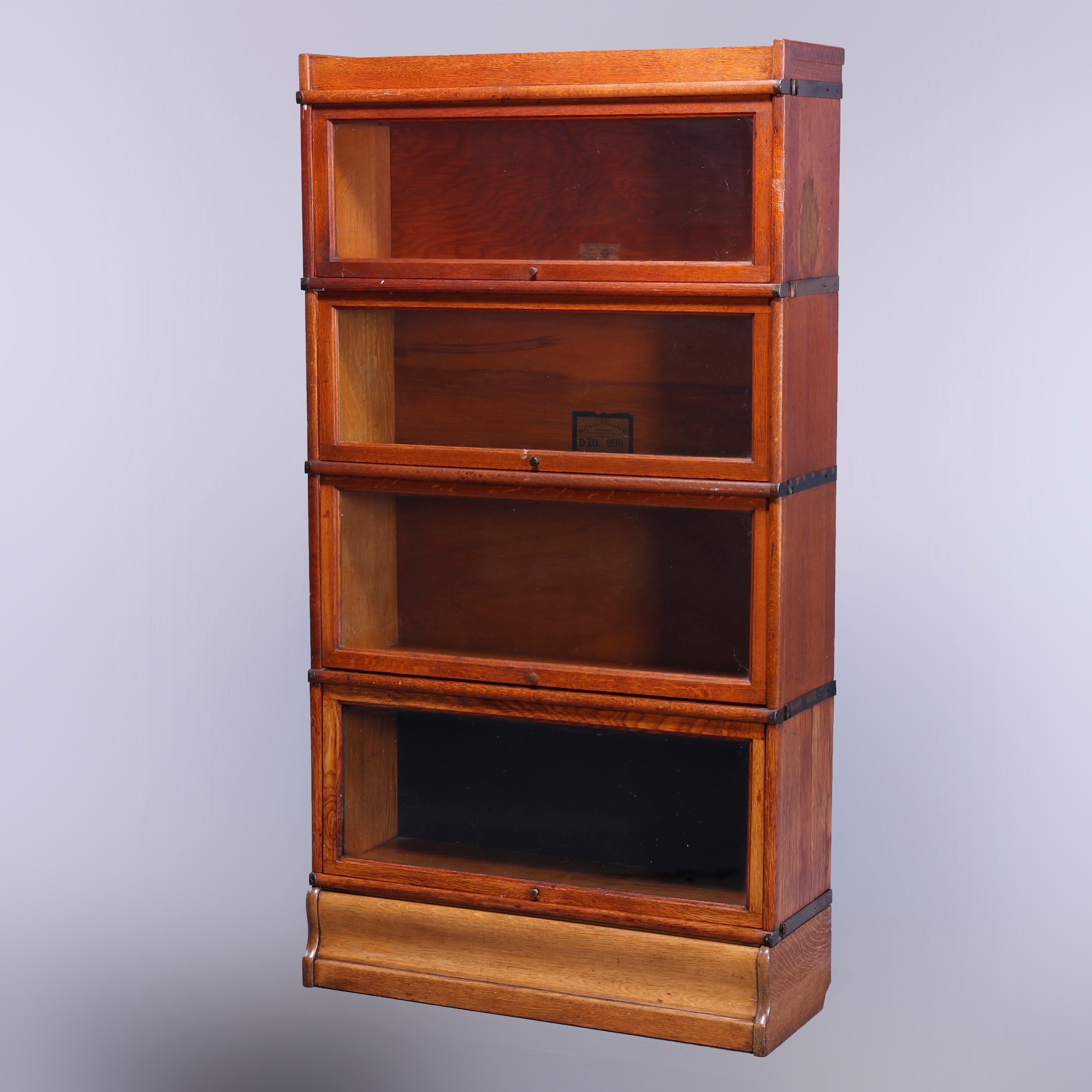 An antique Arts and Crafts barrister bookcase by Globe Wernicke offers quarter sawn oak construction with four stacks, each having pullout glass doors, raised on ogee base, maker labels as photographed, c1910

Measures - 63.5'' H x 34'' W x 12.5''