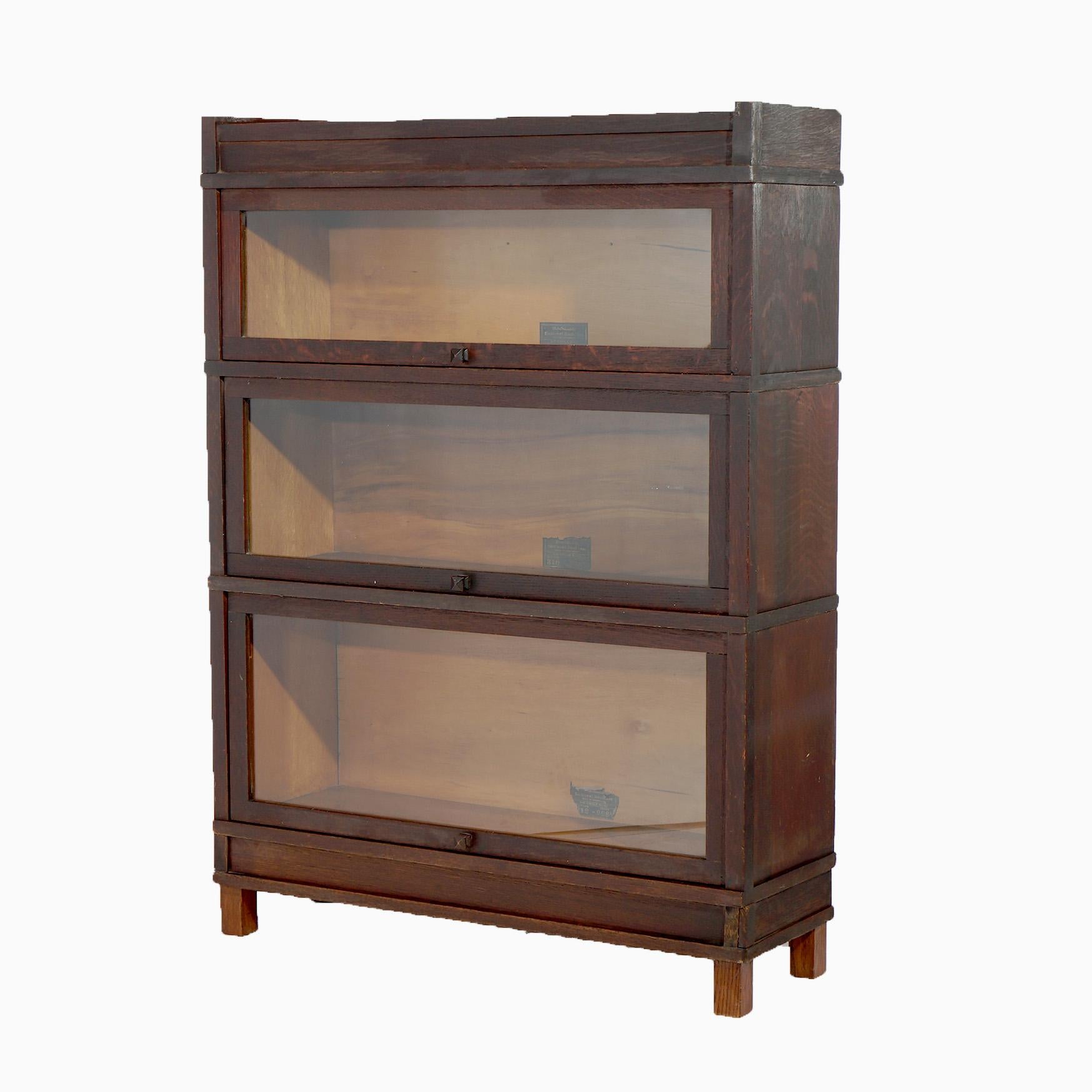 An antique Arts & Crafts barrister bookcase by Globe Wernicke offers oak construction with three stacks, each having pull-out glass doors, raised on square and straight legs, maker label as photographed, c1910
Measures - 47.25