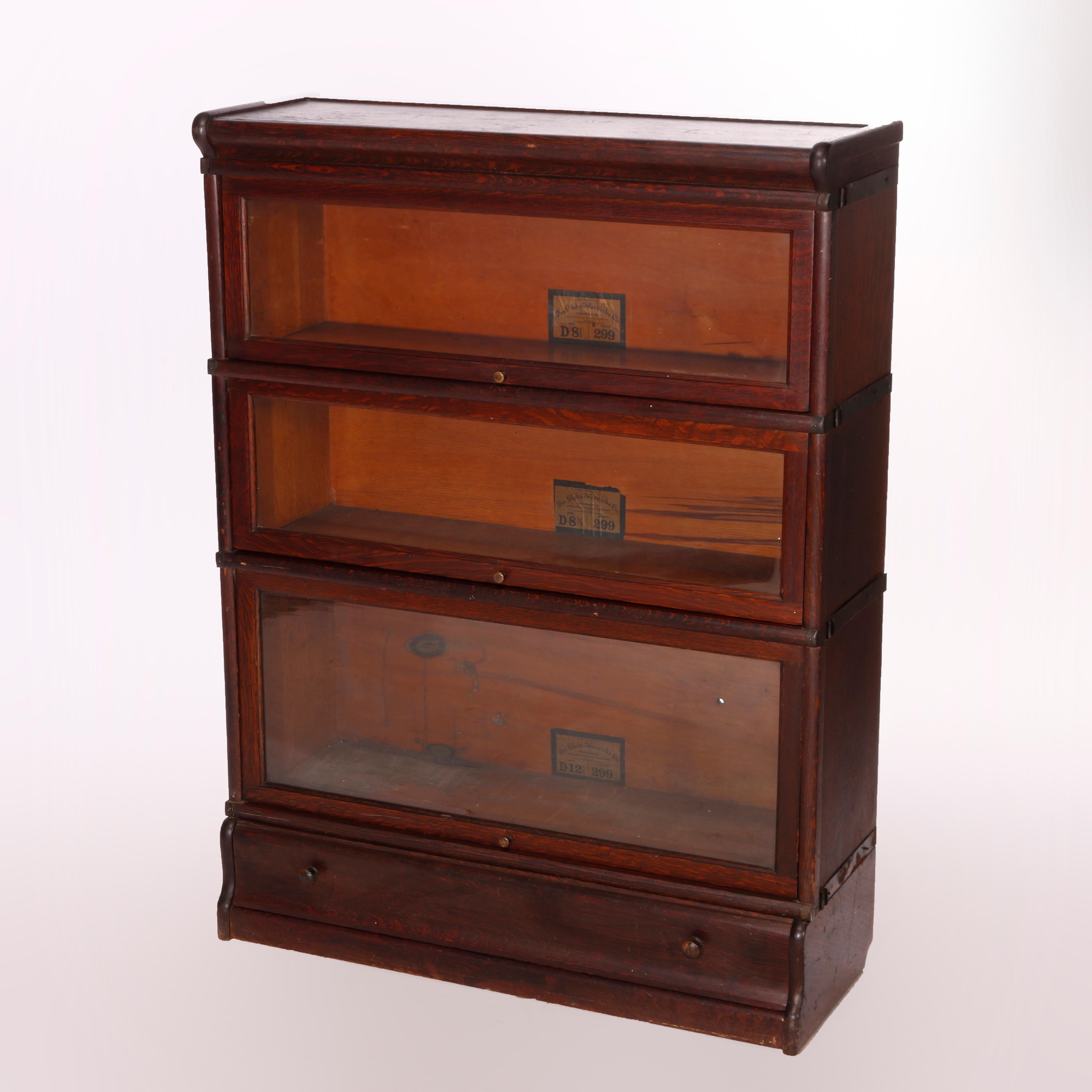 An antique Arts and Crafts Barrister bookcase by Globe Wernicke offers quarter sawn oak construction with three stacks, each having pull out glass doors, raised on ogee base having single drawer, maker labels as photographed, c1910

Measures -