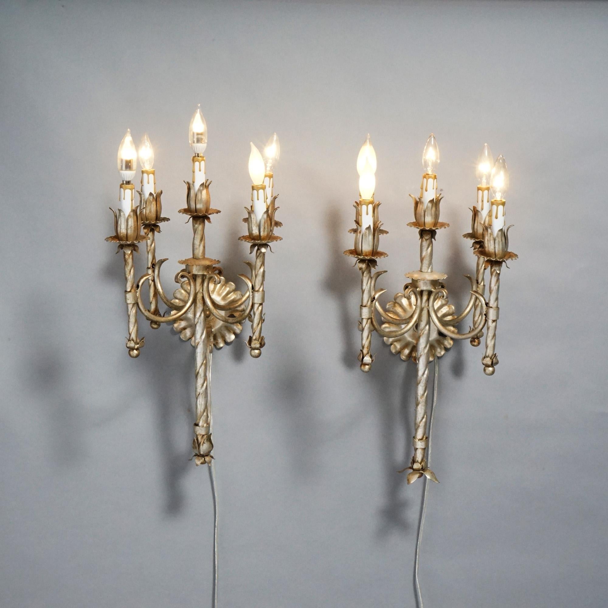 A matching pair of Arts and Crafts candelabra wall sconces offer cast & silvered metal frames with scroll form arms terminating in candle lights with floral receivers, five lights each, 20th century

Measures- 22''H x 11.5''W x 11.5''D.

Catalogue