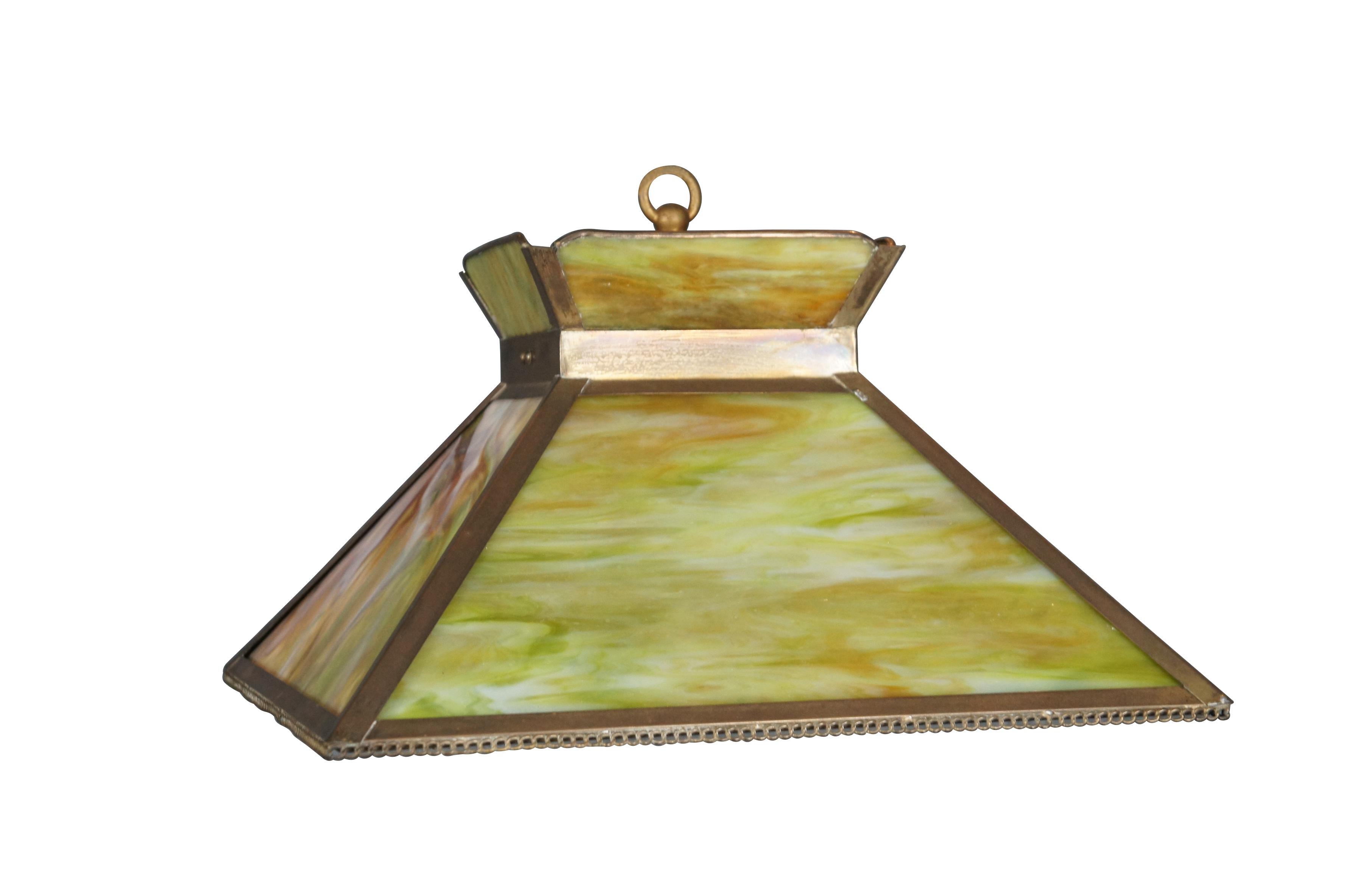 Late 19th century Arts and Crafts mission style swag / pendant light. Pyramid shaped with flared top, trimmed in brass with chain link design along lower edge. Light green and amber stained slag glass panels. Fluted balloon shaped milk glass shade