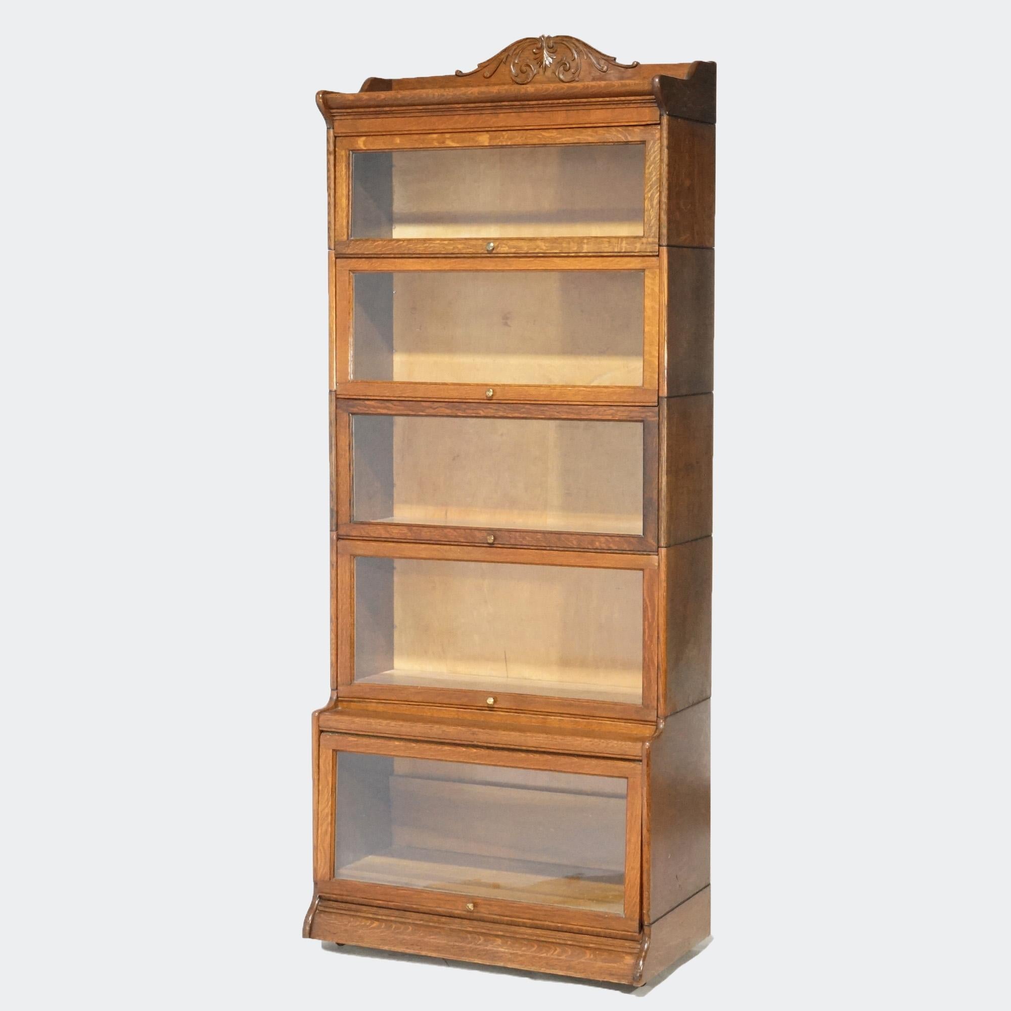 An antique Arts and Crafts barrister bookcase by Gunn offers oak construction with five stacks, each having pull-out glass doors, raised on an ogee base, maker label as photographed, circa 1910

Measures - 86