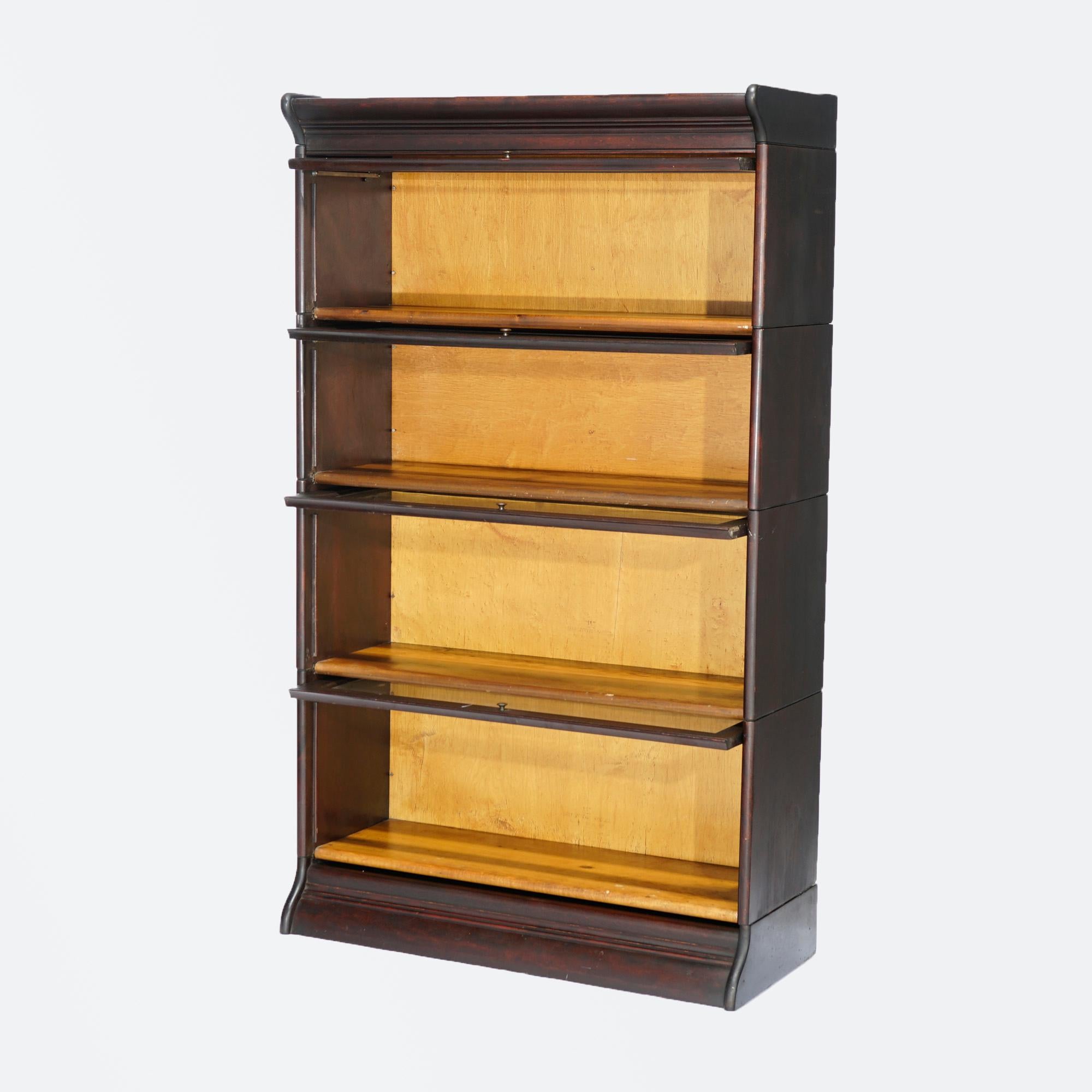 An antique Arts & Crafts barrister bookcase by Gunn offers mahogany construction with four stacks, each having pull out glass doors and seated on ogee base as photographed, c1890

Measures- 58''H x 34.25''W x 14.25''D.

Catalogue Note: Ask about