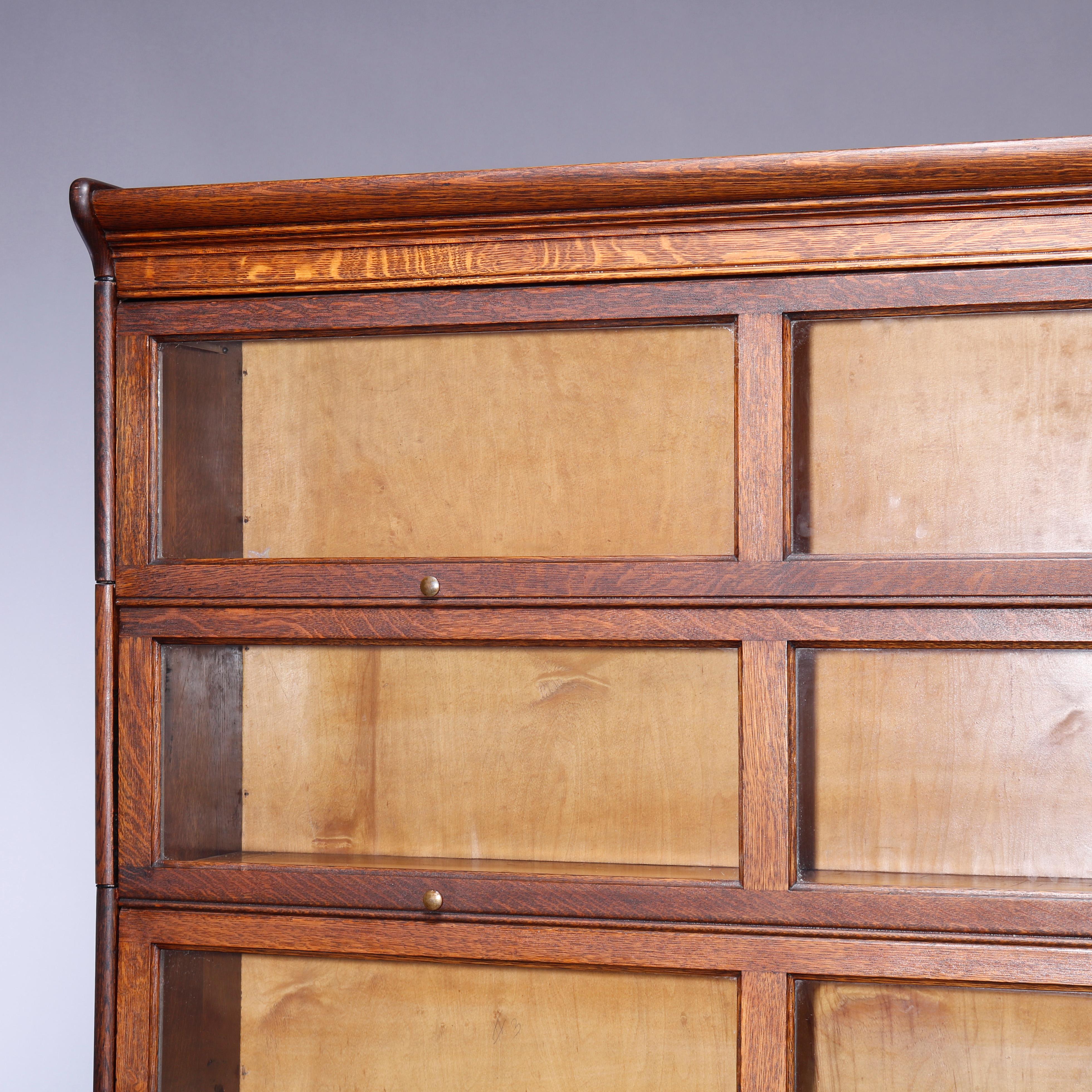 An antique Arts & Crafts Mission barrister bookcase by Gunn offers quarter sawn oak construction with six double-length stacks, each having a pull-out glass door and seated on ogee base, C1910

Measures: 81