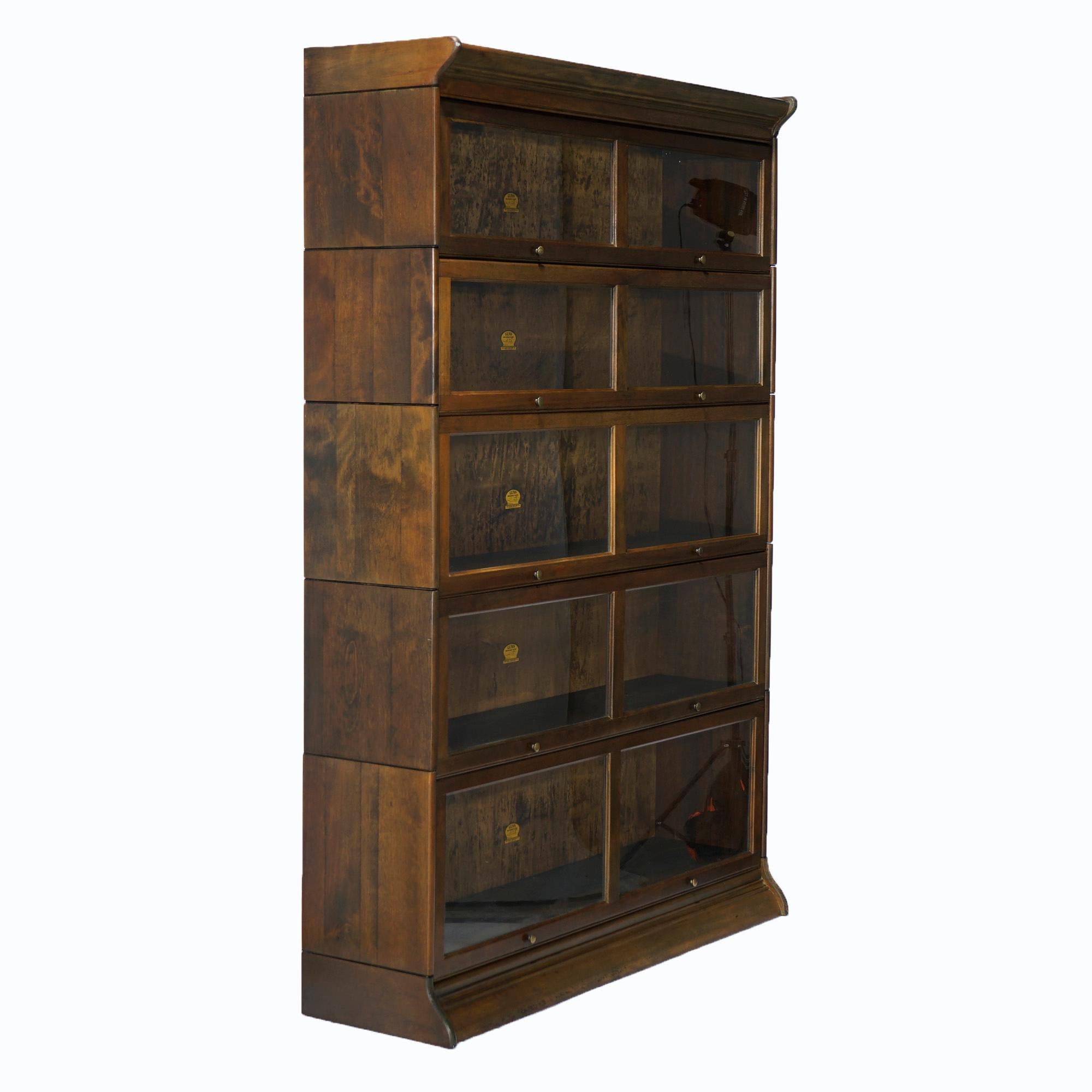 An antique Arts & Crafts double barrister bookcase by Gunn offers mahogany construction with five stacks, each with pull out glass doors and raised on ogee base, maker label as photographed, c1910.

Measures- overall 72.75''H x 50.5''W x 14.5''D;