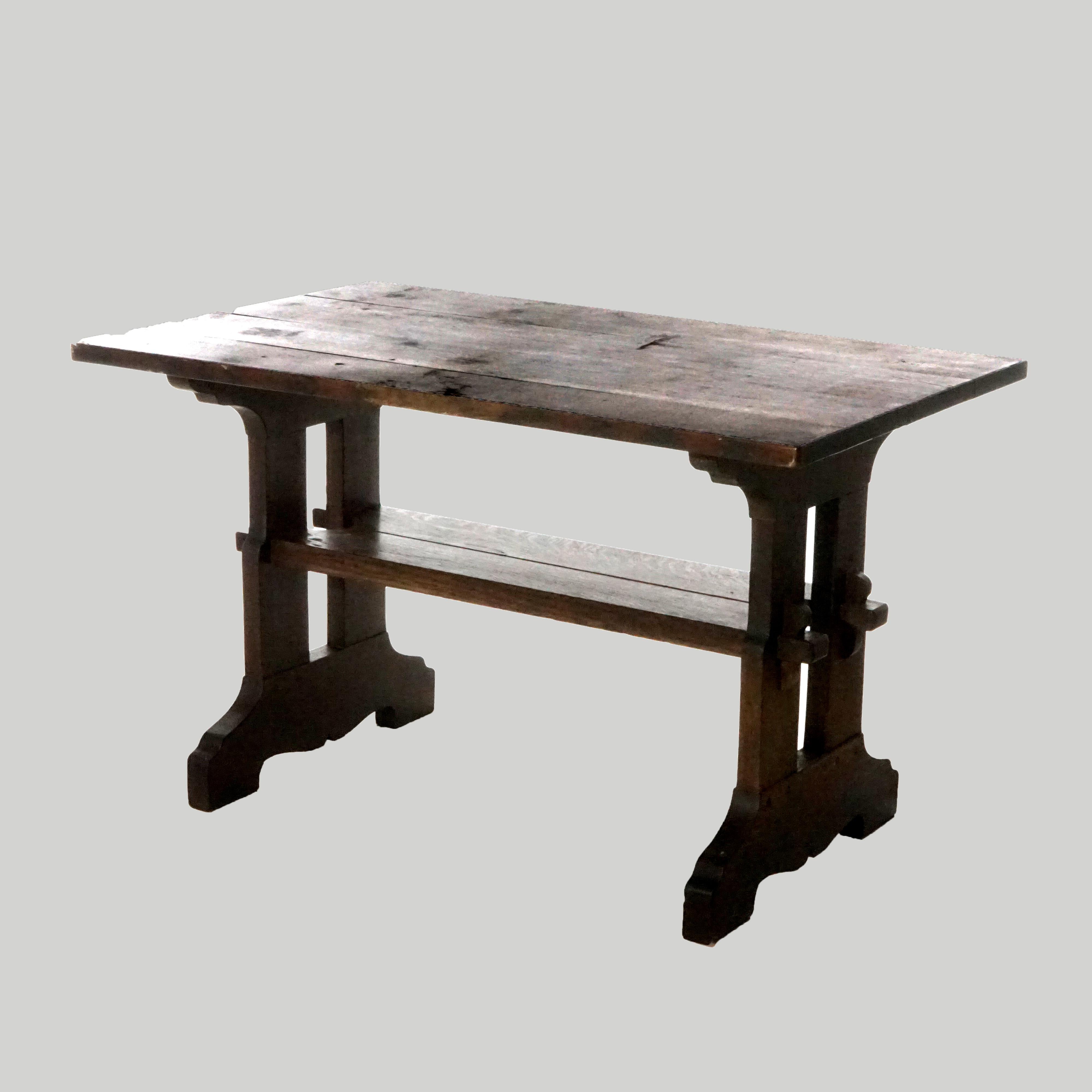 An antique Arts and Crafts Gustav Stickley Mission table offers oak construction with top raised on cut out mortise and tenon base with lower shelf, c1910

Measures- 29'' H x 48.25'' W x 29.75'' D.