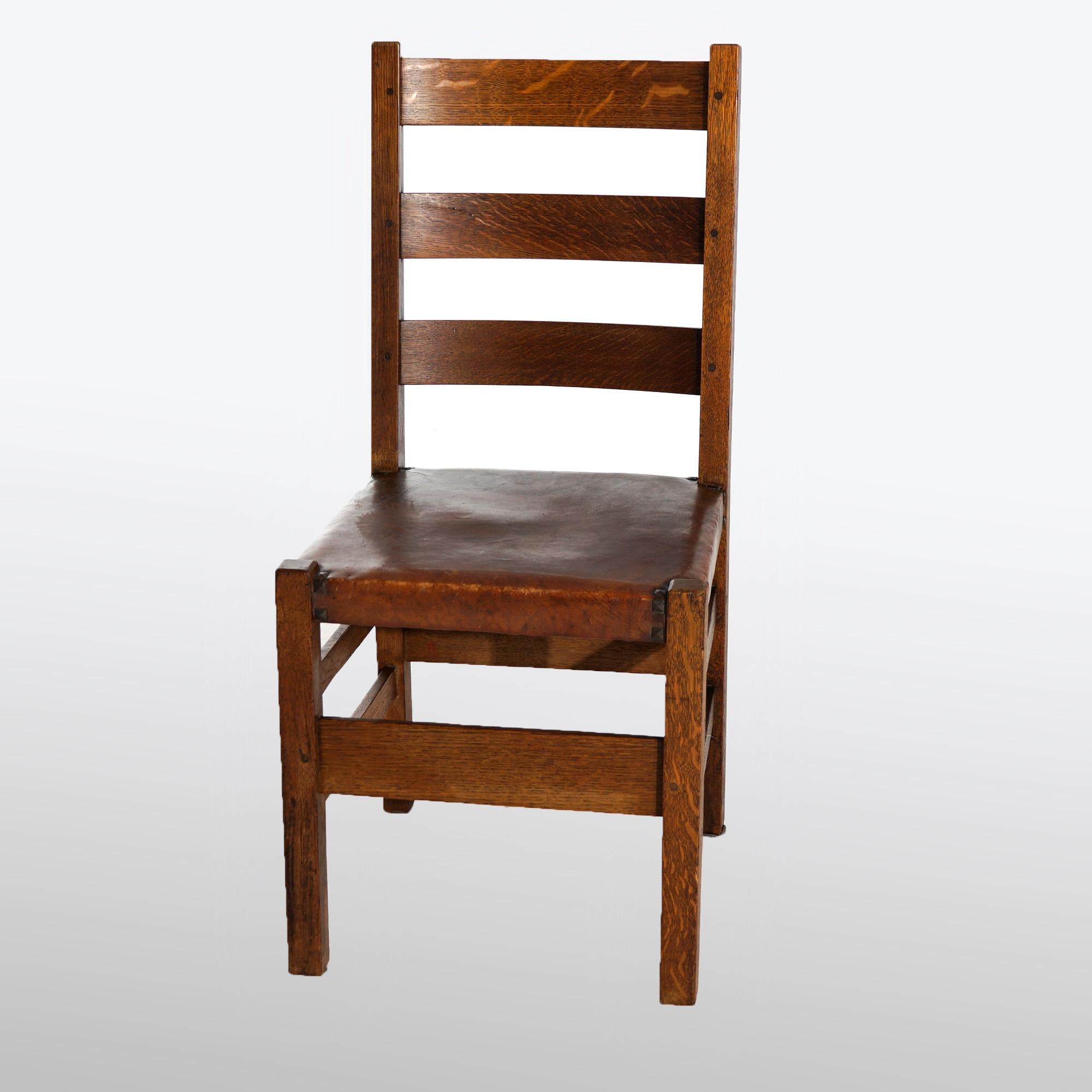 An antique Arts and Crafts set of six dining chairs by Gustav Stickley offer quarter sawn oak construction with ladder back over original seats and tacks, maker label as photographed, c1910

Measures- 36.25'' H x 17'' W x 19'' D; seat height