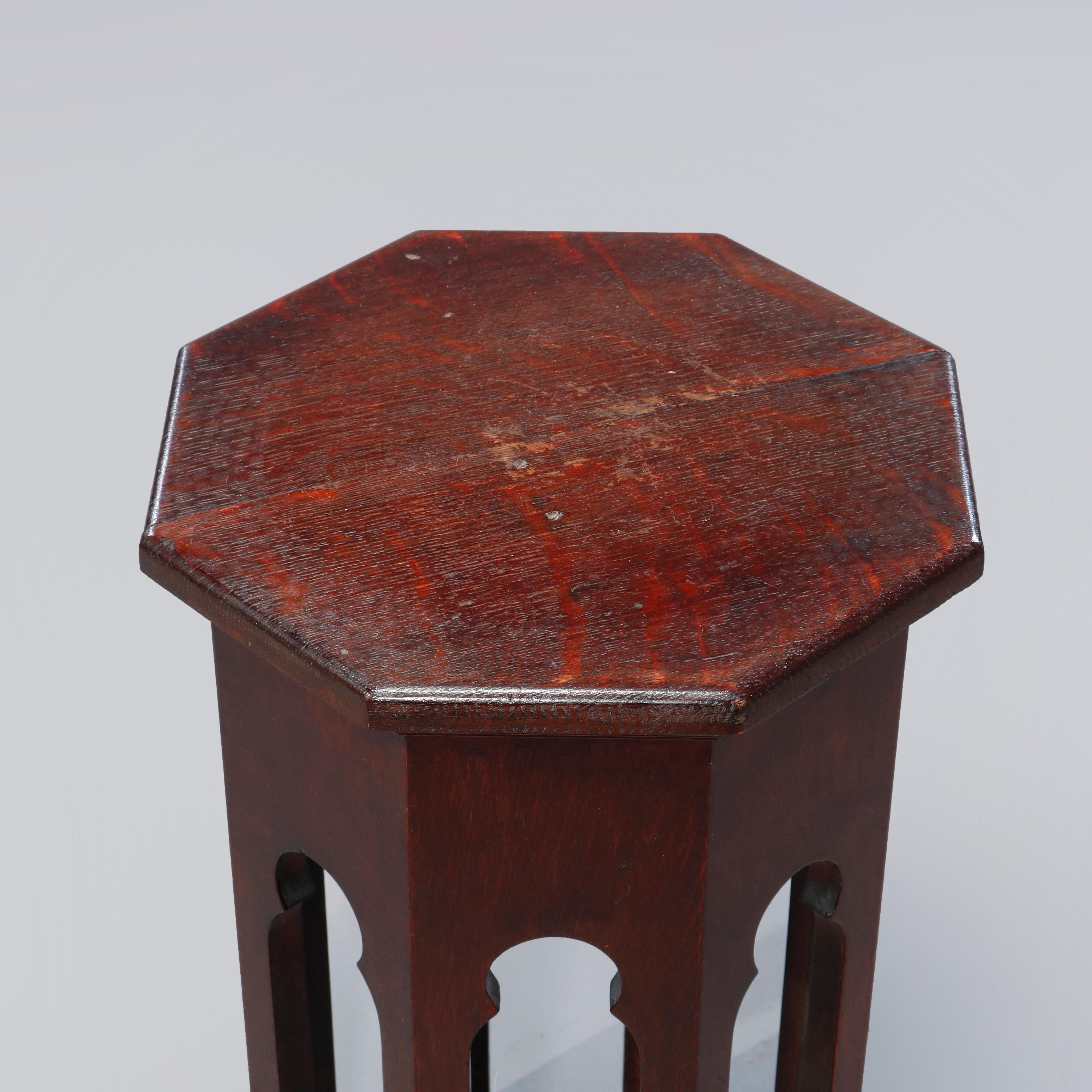 An Arts & Crafts tabouret stand in the manner of Gustav Stickley Tobey offers octagonal top over cutout Gothic cathedral arch form legs, c1910.

Measures: 25