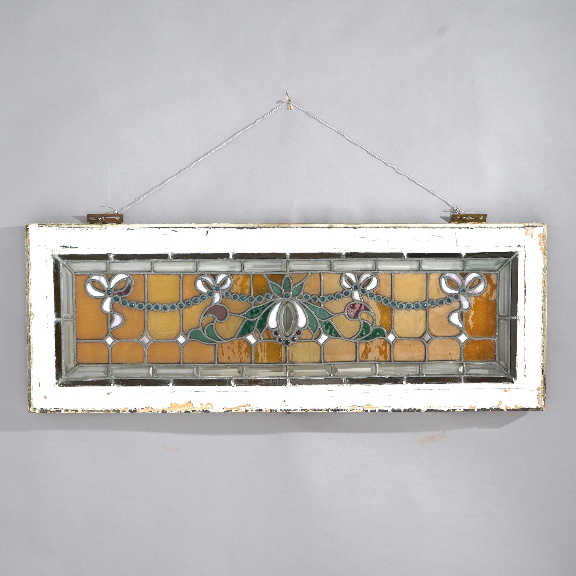 ***Ask About Discounted In-House Shipping***
An antique Arts & Crafts window offers leaded stained and jeweled glass in stylized floral and garland design seated in wood sash, c1910

Measures - 17