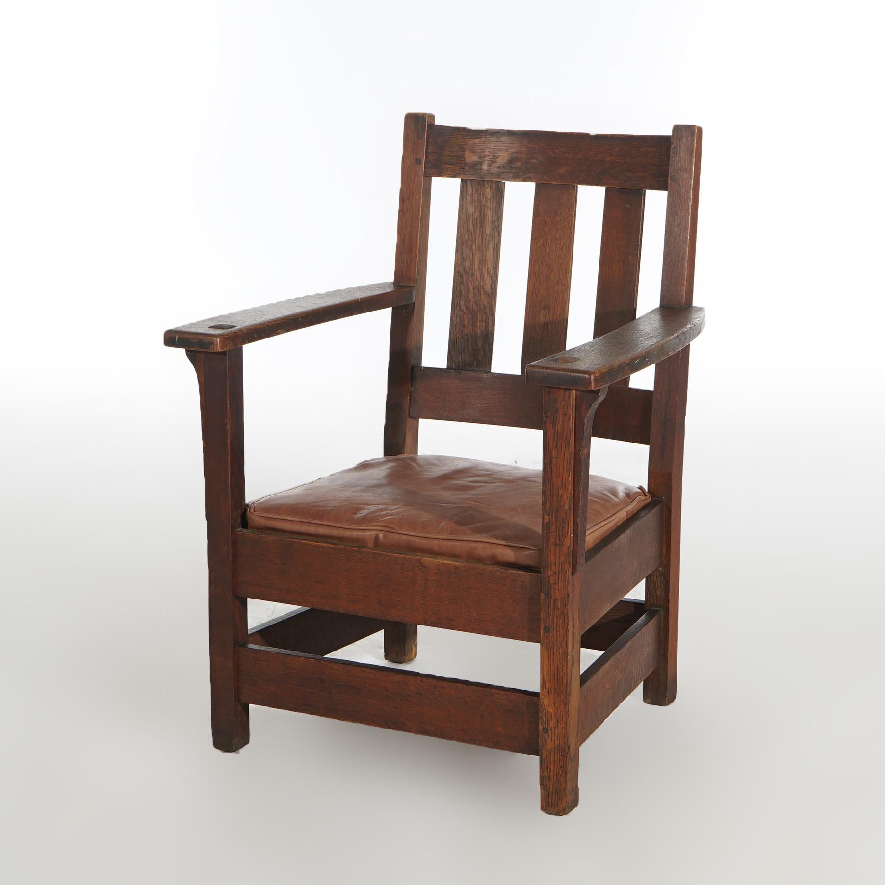 ***Ask About Discounted In-House Shipping***
An antique Arts and Crafts armchair by Limbert offers oak construction with slat back and leather seat, signed under arm, c1815

Measures- 36.5''H x 27.5''W x 26''D; 16''SH