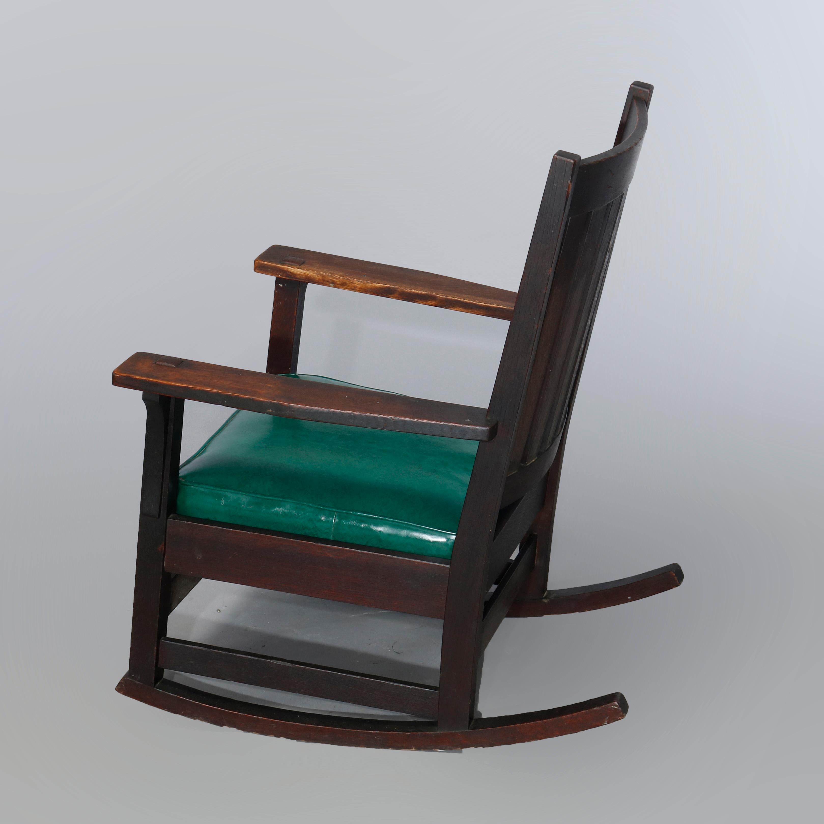 An antique Arts & Crafts Mission rocking chair by L & JG Stickley Handicraft offers handcrafted oak construction with slat back, signed, c1910

Measures: 34.5