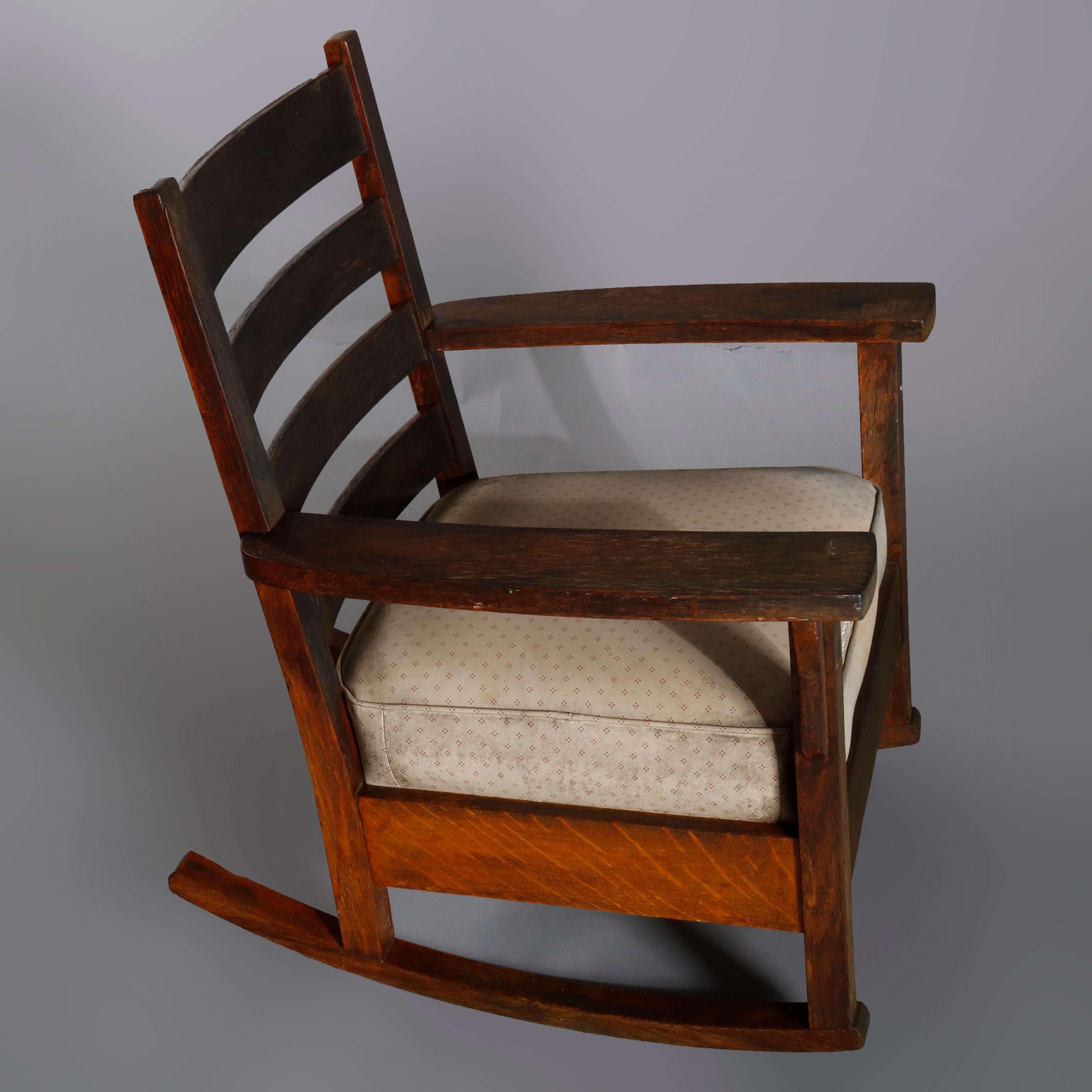 An Arts & Crafts Mission oak rocking chair in the manner of L & JG Stickley offers slat back over upholstered cushion seat, most likely by J.M. Young although does not bear a maker label to confirm, circa 1910. 

Measures: 34.5