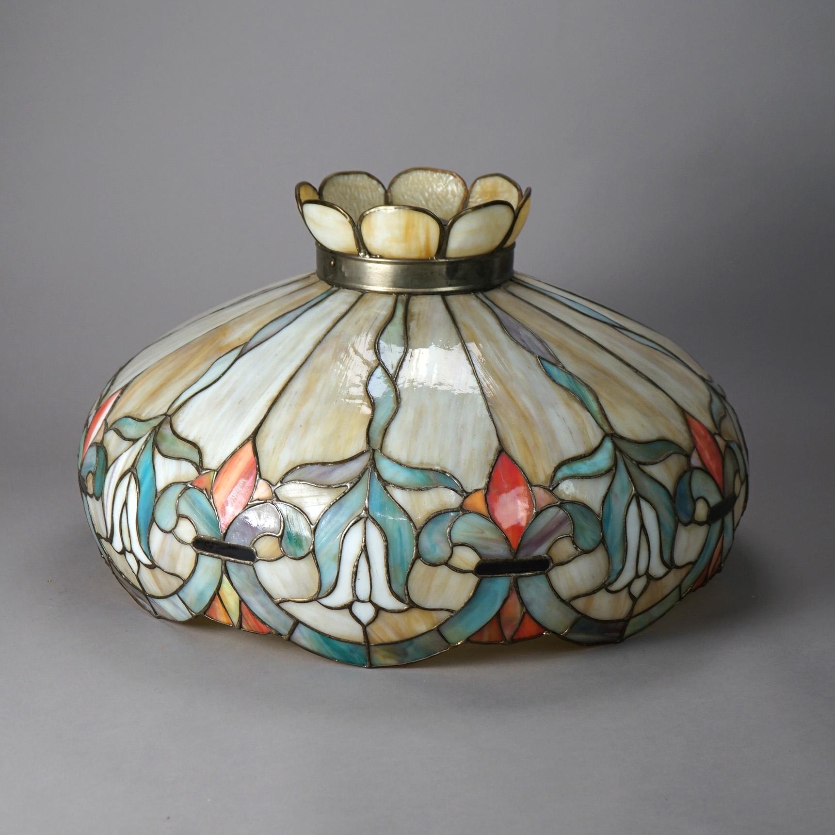 An antique Arts and Crafts shade offers leaded slag glass in dome form with stylized flowers, circa 1910

Measures - 14.5