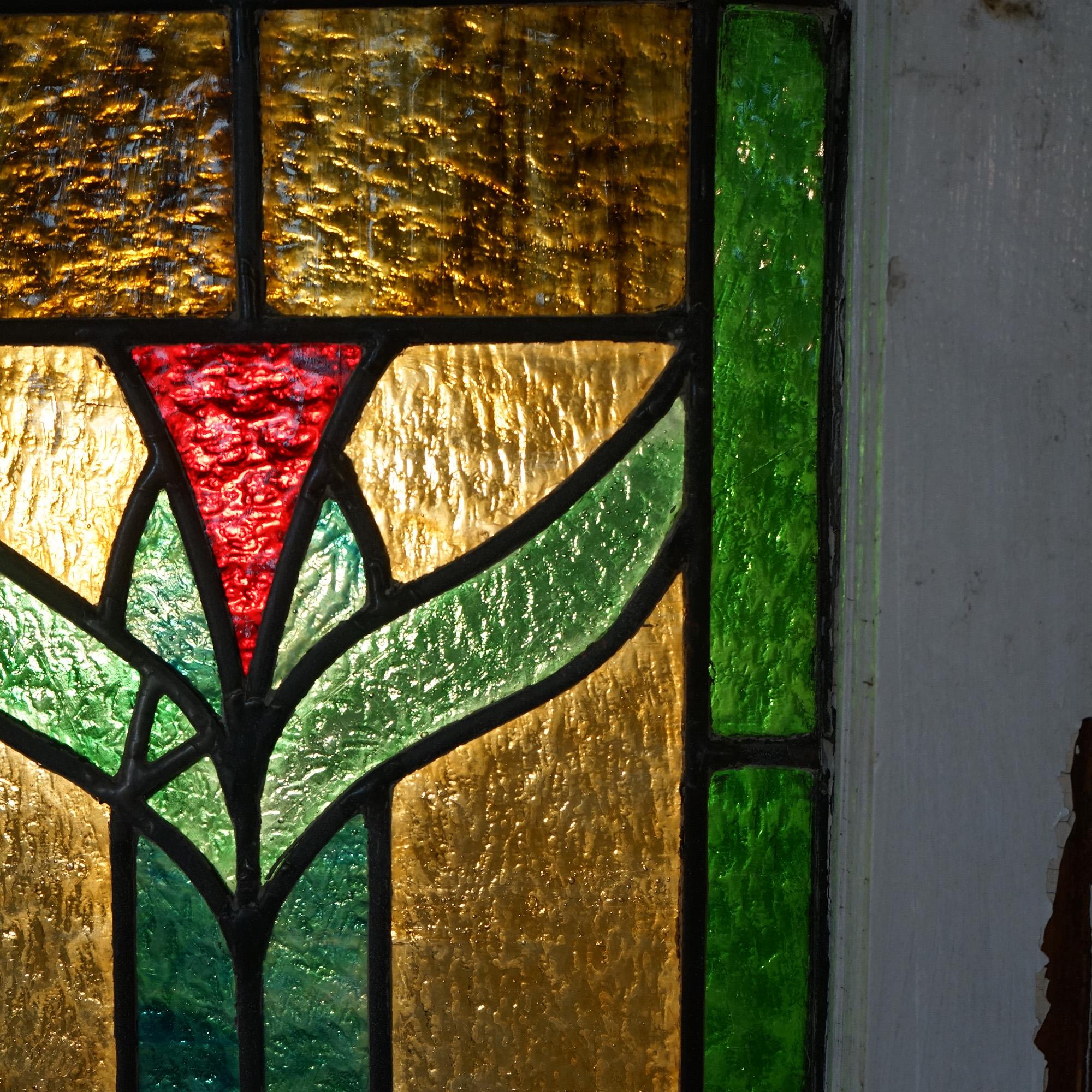 Une fenêtre ancienne de style Arts and Crafts offre des scories et des vitraux au plomb dans un motif floral stylisé, assis dans un châssis en bois, vers 1910.

Mesures : 30,75''H x 59''L x 2''D