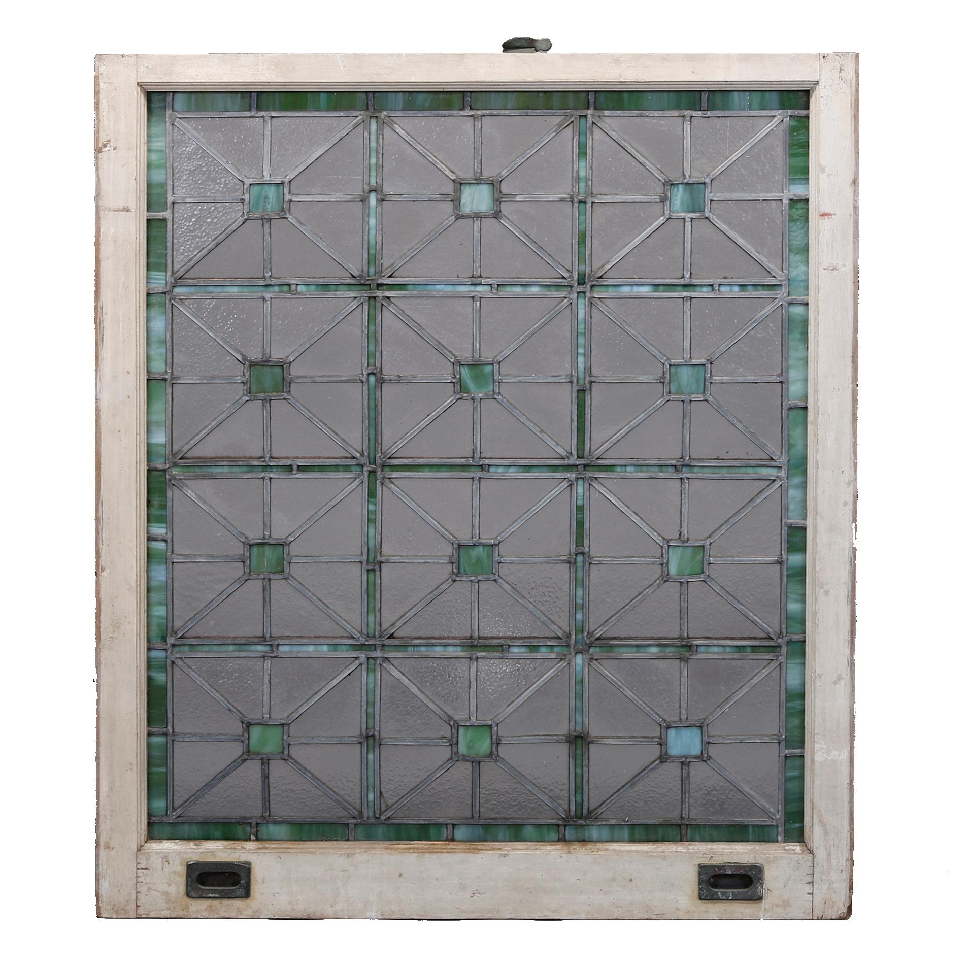 An antique Arts and Crafts Frank Lloyd Wright style Prairie School leaded slag and modeled glass window offers repeating pattern on geometric panels in emerald green and colorless glass, c1910.

Measures: 41.5