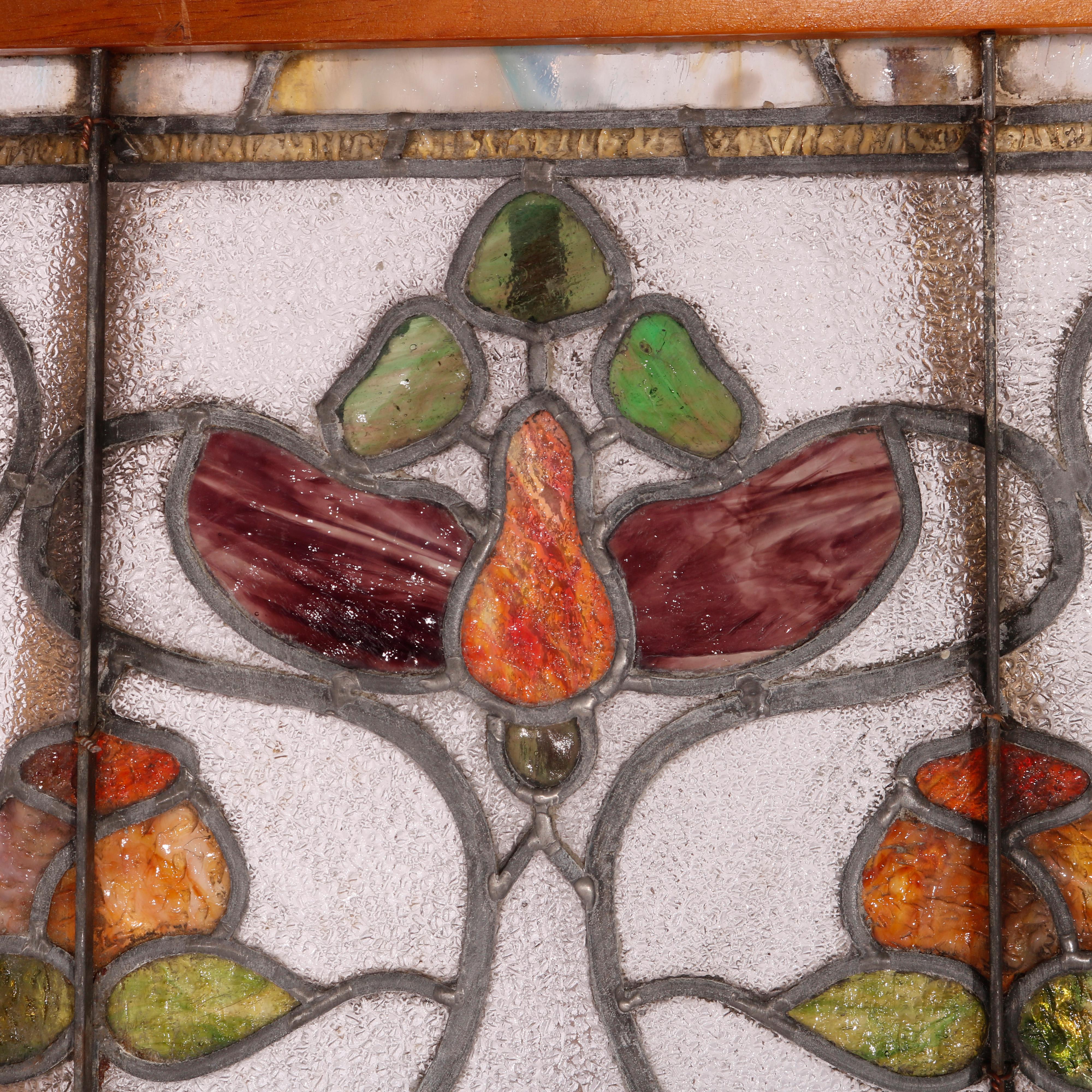 An antique Arts & Crafts (elements of Art Nouveau) window offers leaded stained glass construction with stylized tulip design, seated in wood sash, circa 1910

Measures - 23.75