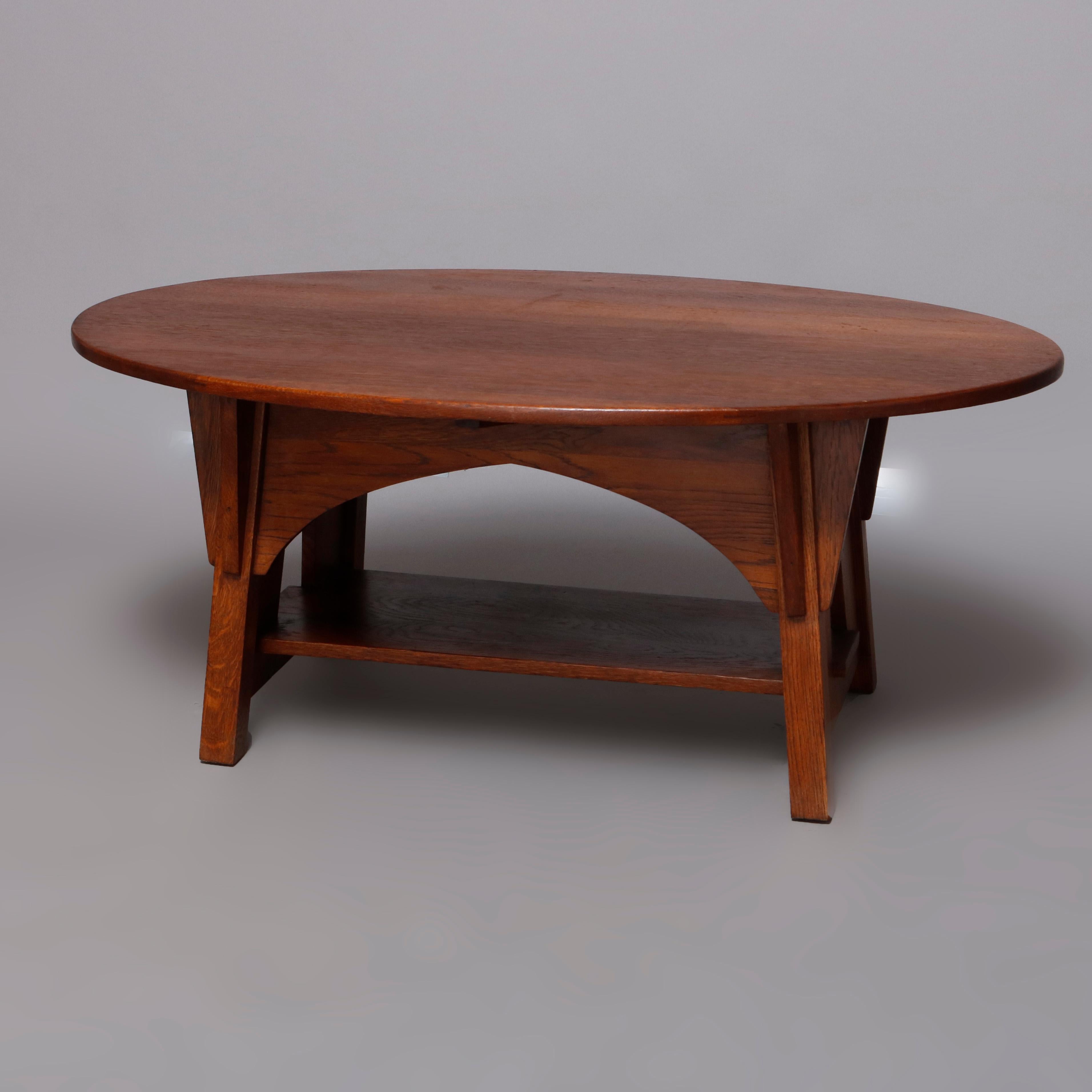 An antique Arts & Crafts mission oak coffee table by Limbert offers oval form with cut out trestle legs and having arched skirt, maker label on top verso as photographed, circa 1910

Measures: 19