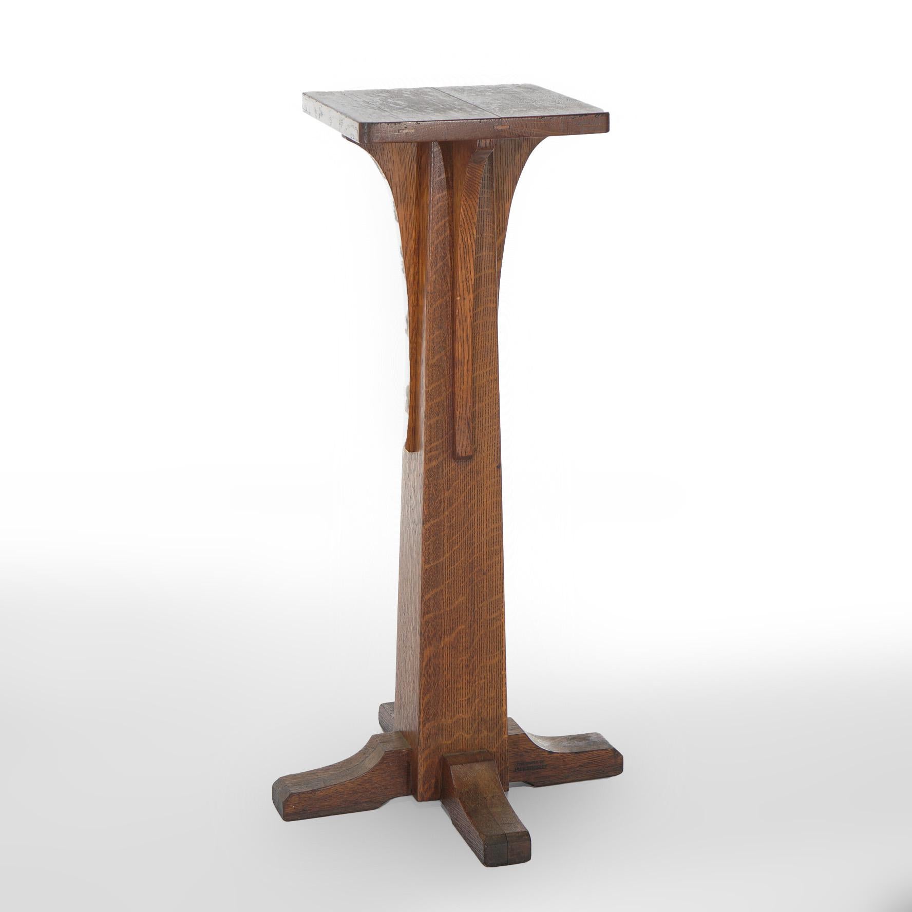 An antique Arts and Crafts plant or sculpture stand offers quarter sawn oak construction with spline top over flared column base having elongated corbels and shoe feet, c1910

Measures - 36