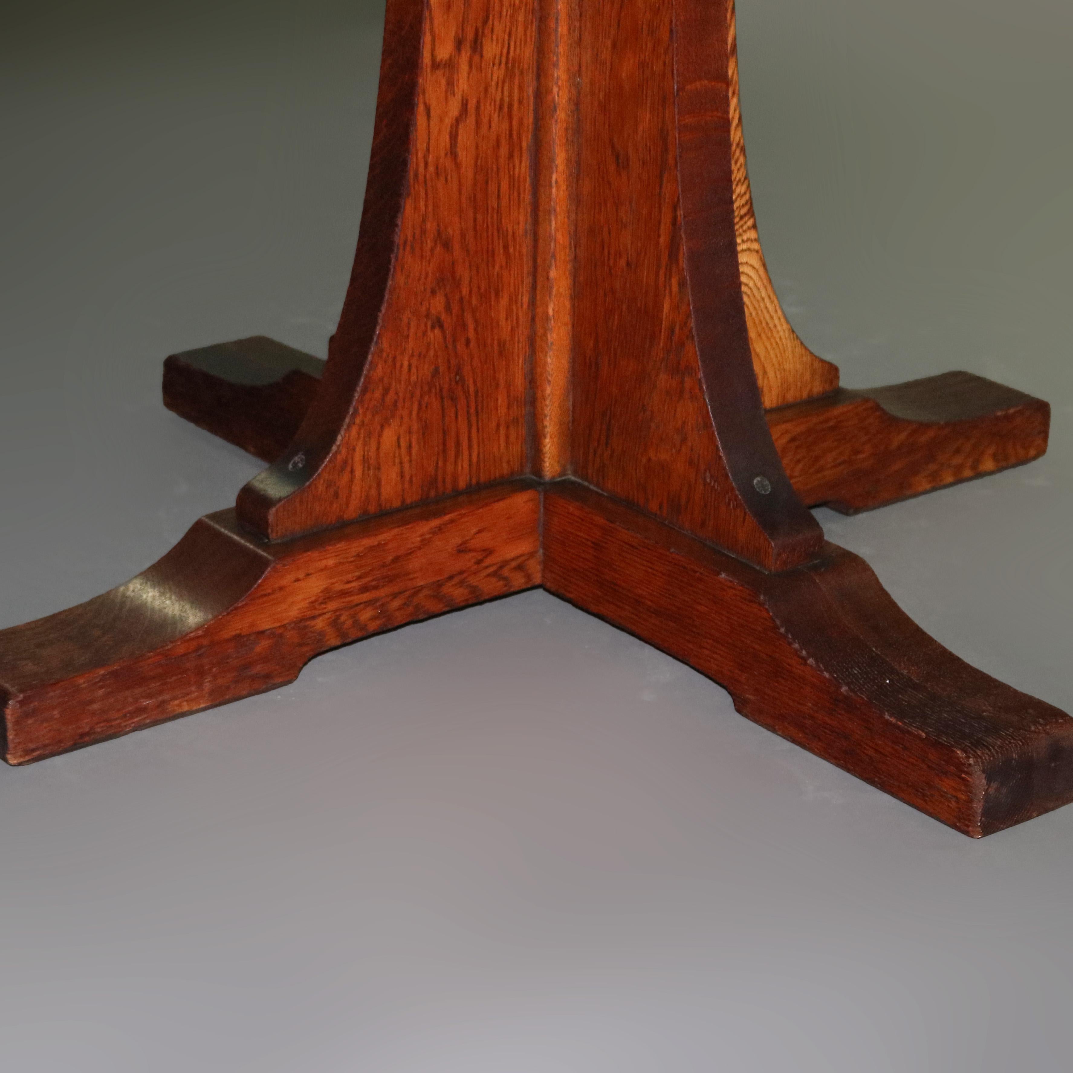 An Arts & Crafts mission oak dining table by L&JG Stickley offers skirted extension top with four leaves surmounting corbeled pedestal with shoe foot, circa 1910. 

Measures: 30