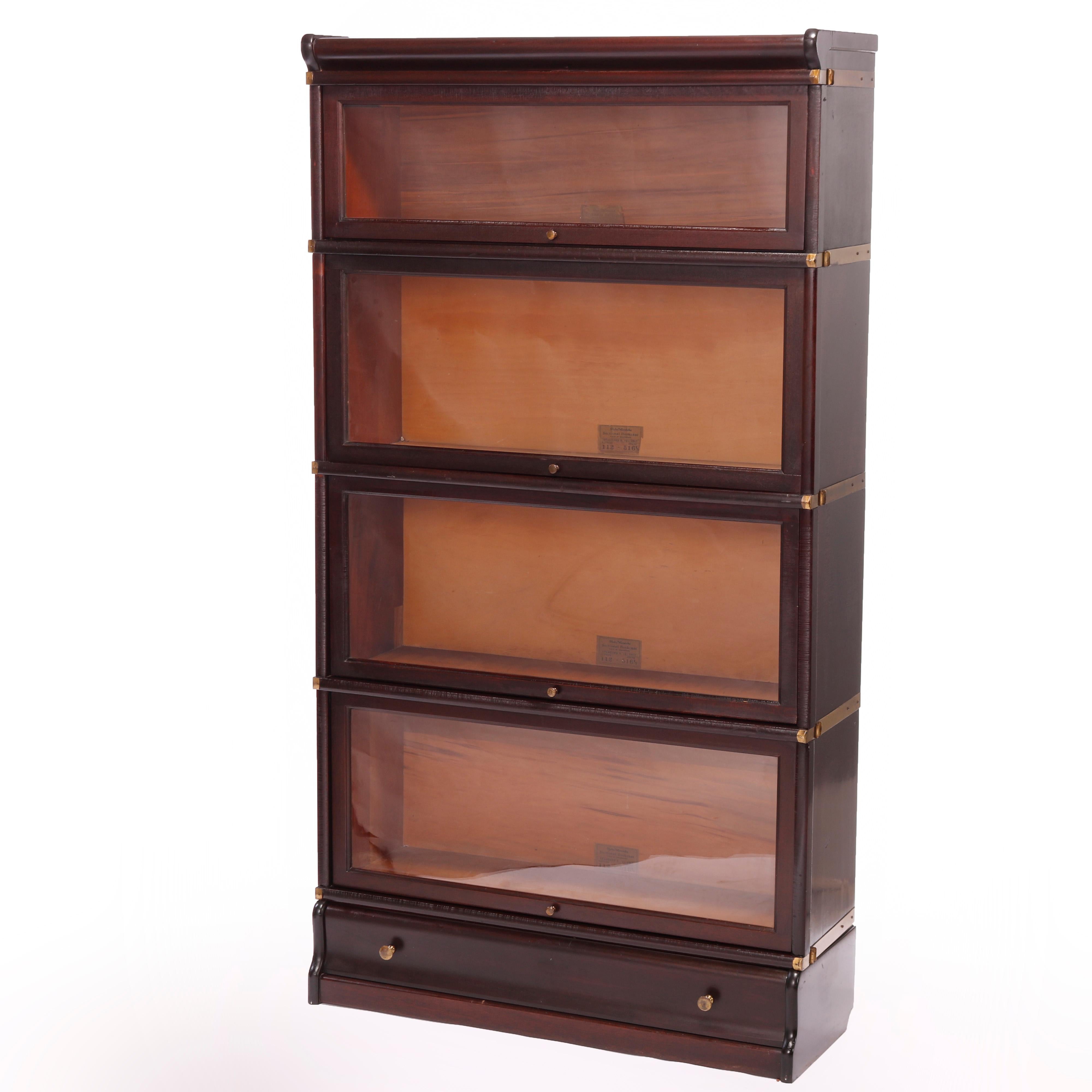 An antique Arts and Crafts Barrister bookcase by Globe Wernicke offers oak construction with four stacks, each having pull out glass doors and seated on ogee base with drawer, maker label as photographed, c1910

Measures - 63.5''H x 34.25''W x