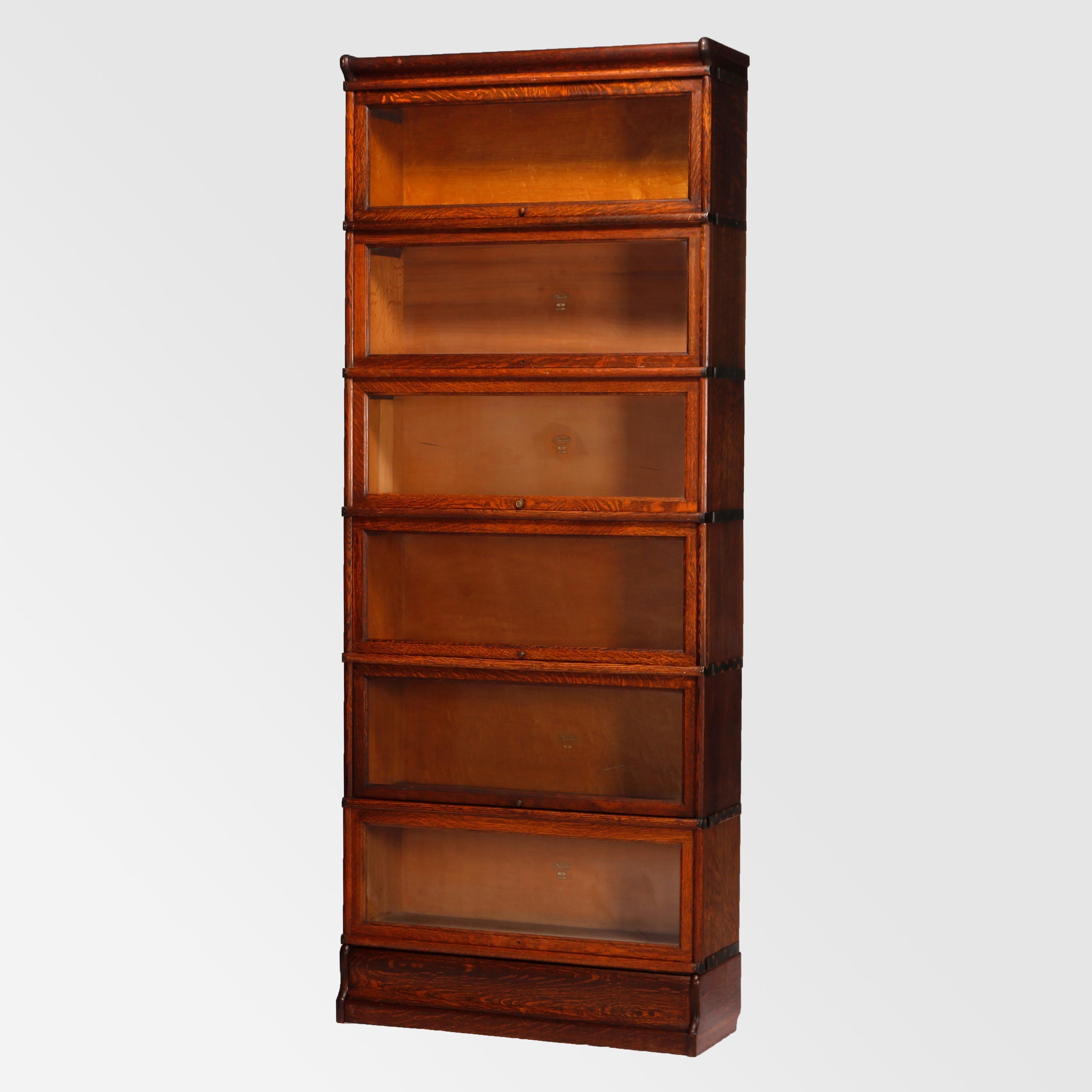 An antique Arts & Crafts Barrister bookcase by Macey offers oak construction with six stacks, each having pull out glass doors and seated on ogee base, maker label as photographed, c1910

Measures - 86'' H x 34.25'' W x 12.5'' D.

Catalogue Note: