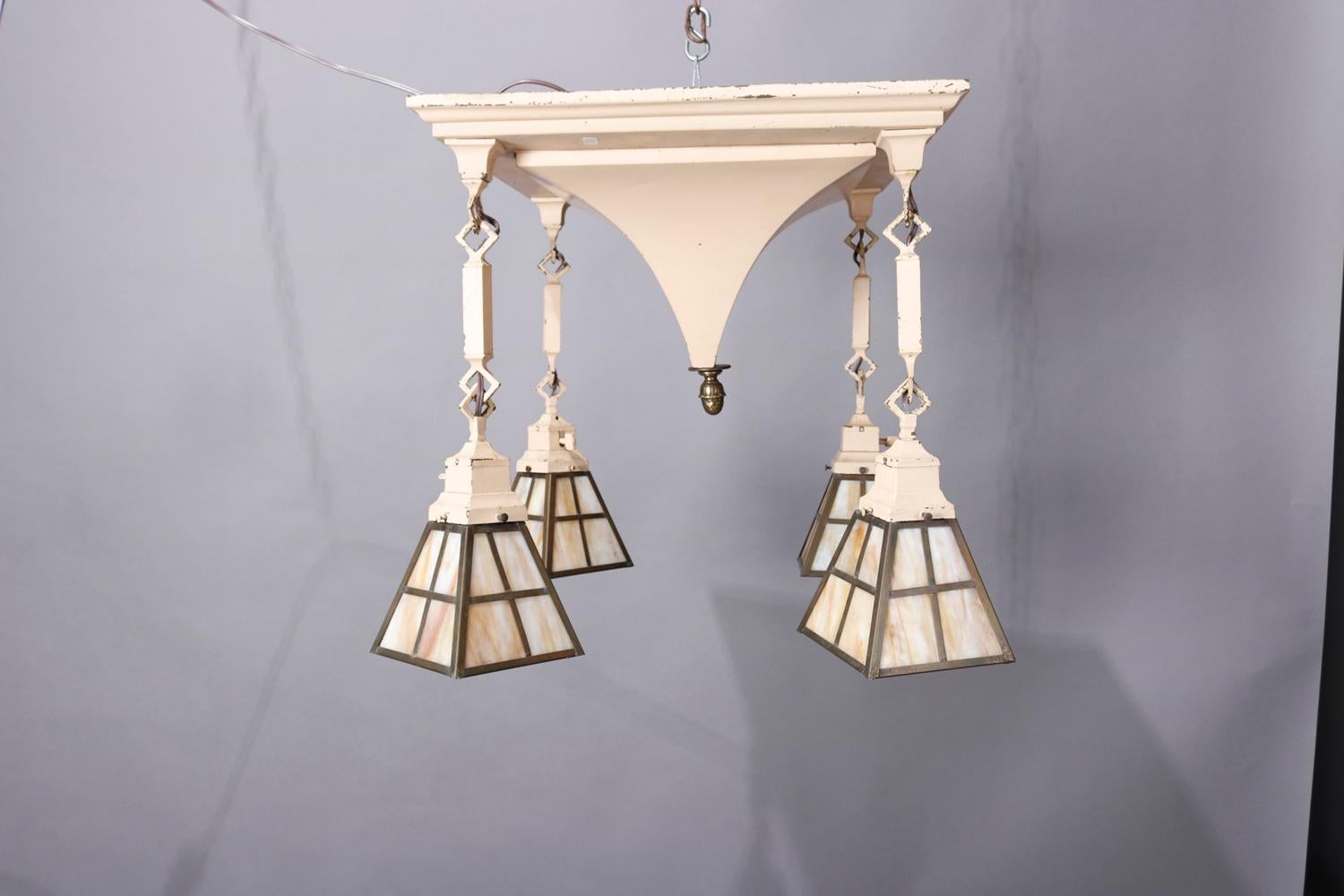An Arts & Crafts hanging light offers painted metal construction with pyramidal form ceiling cover with four drop slag glass lights, 20th century. 

***DELIVERY NOTICE – Due to COVID-19 we are employing NO-CONTACT PRACTICES in the transfer of