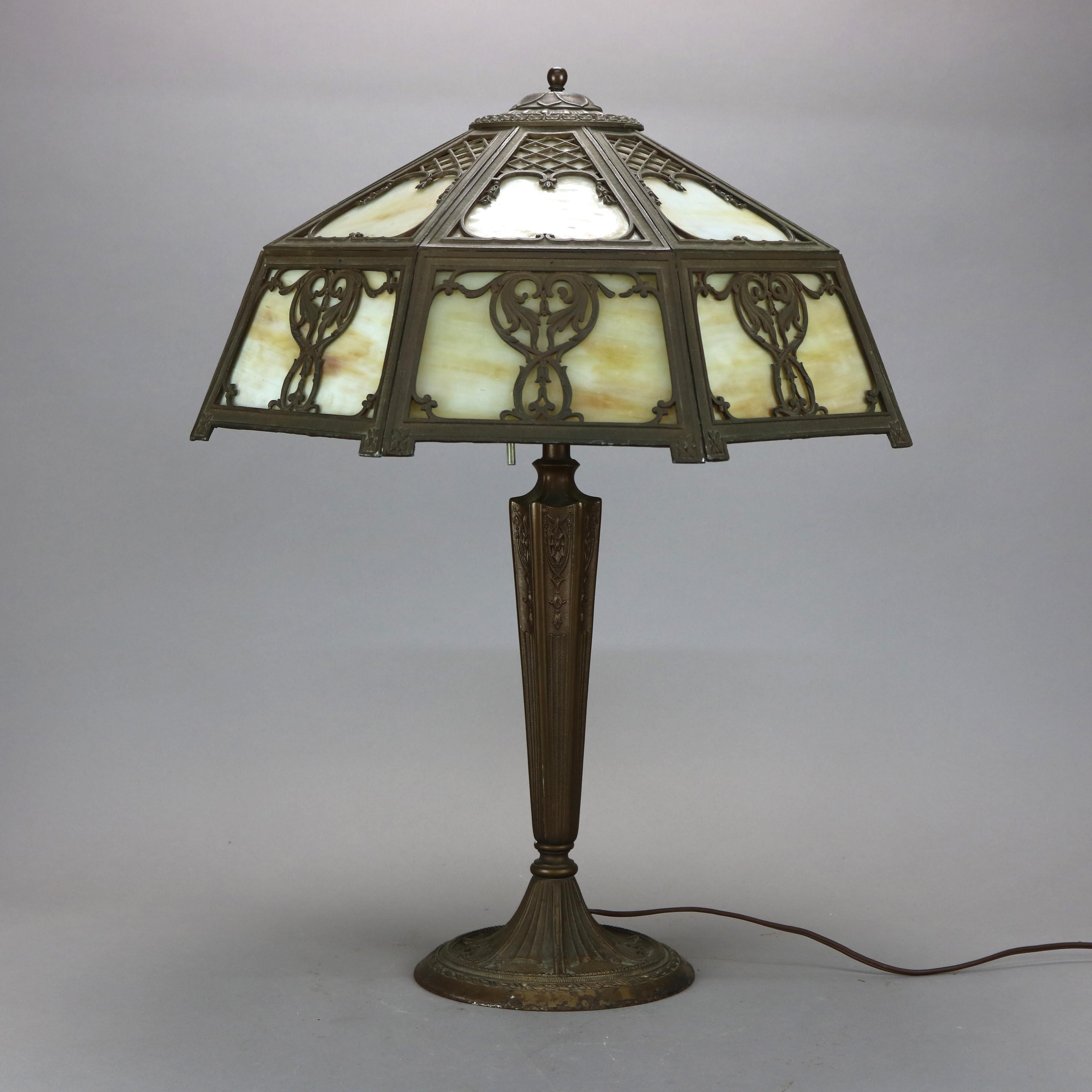 An antique Arts & Crafts table lamp in the manner by Miller Lamp Co offers scroll, foliate and lattice filigree shade housing slag glass panels over double socket cast base, embossed maker mark on base as photographed, c1920

Measures - 25'' H x